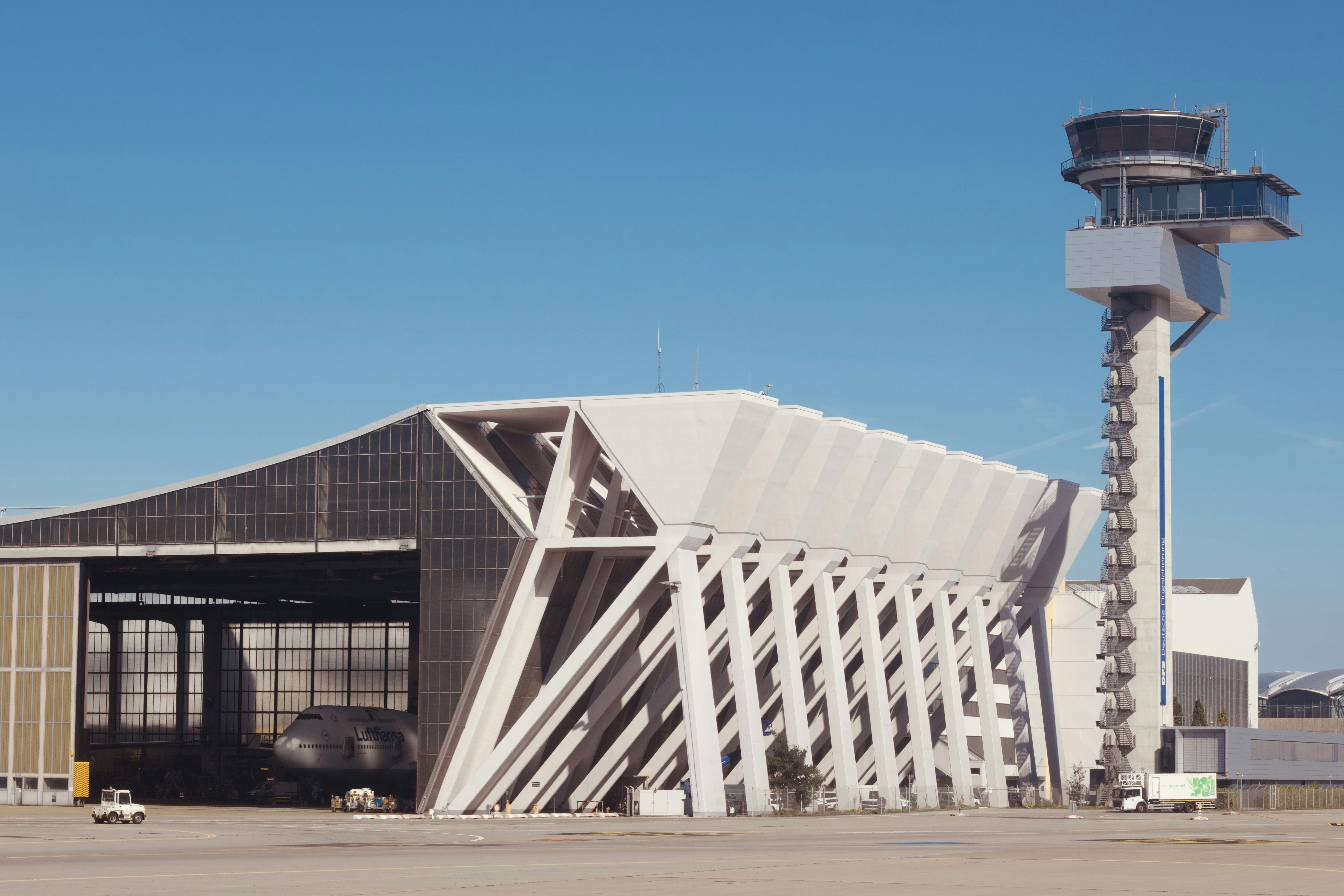 Modern airport hangar with control tower under blue sky