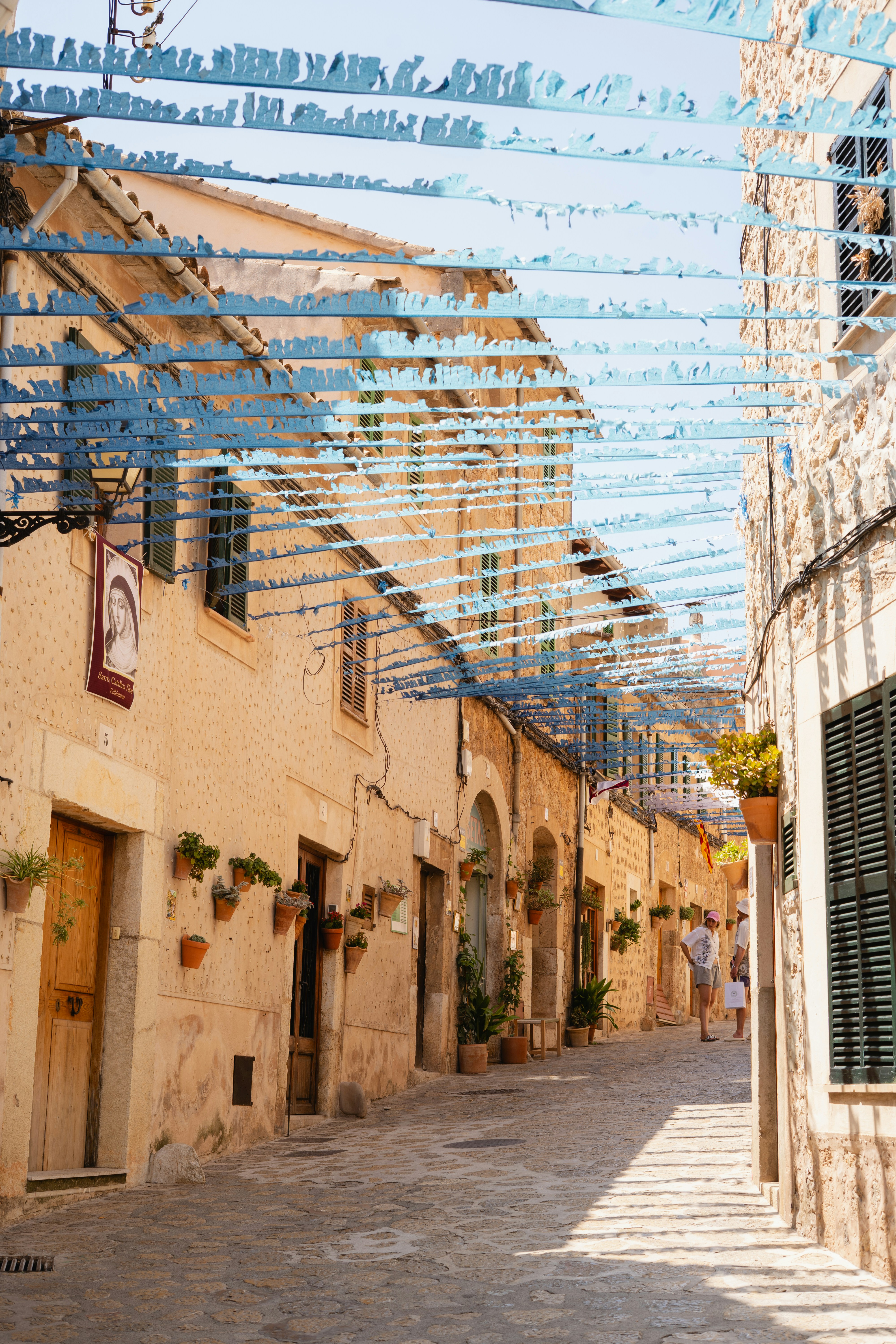 Stretta strada europea decorata con stelle filanti festive blu.