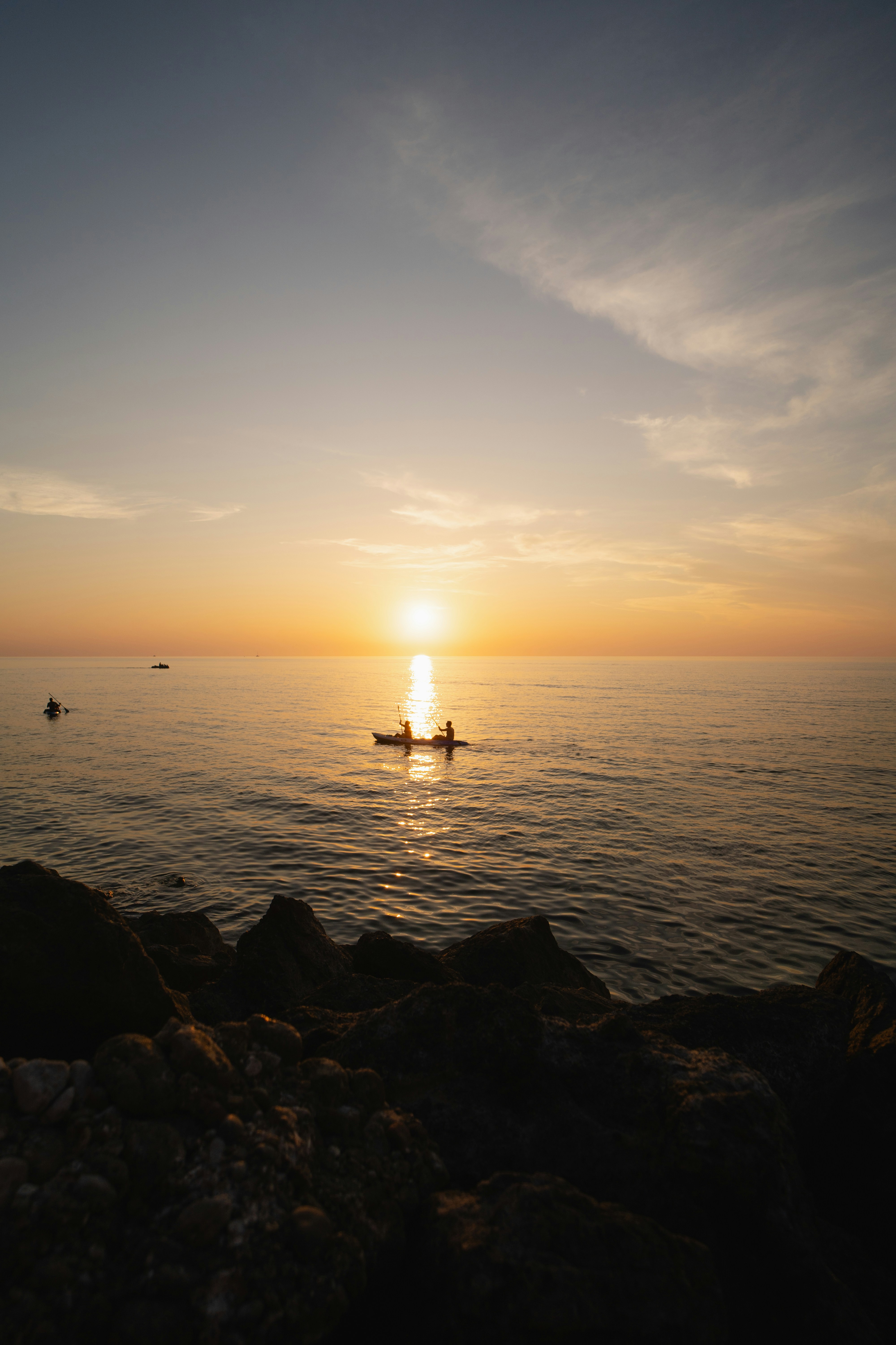 Due persone in una canoa sull'oceano al tramonto