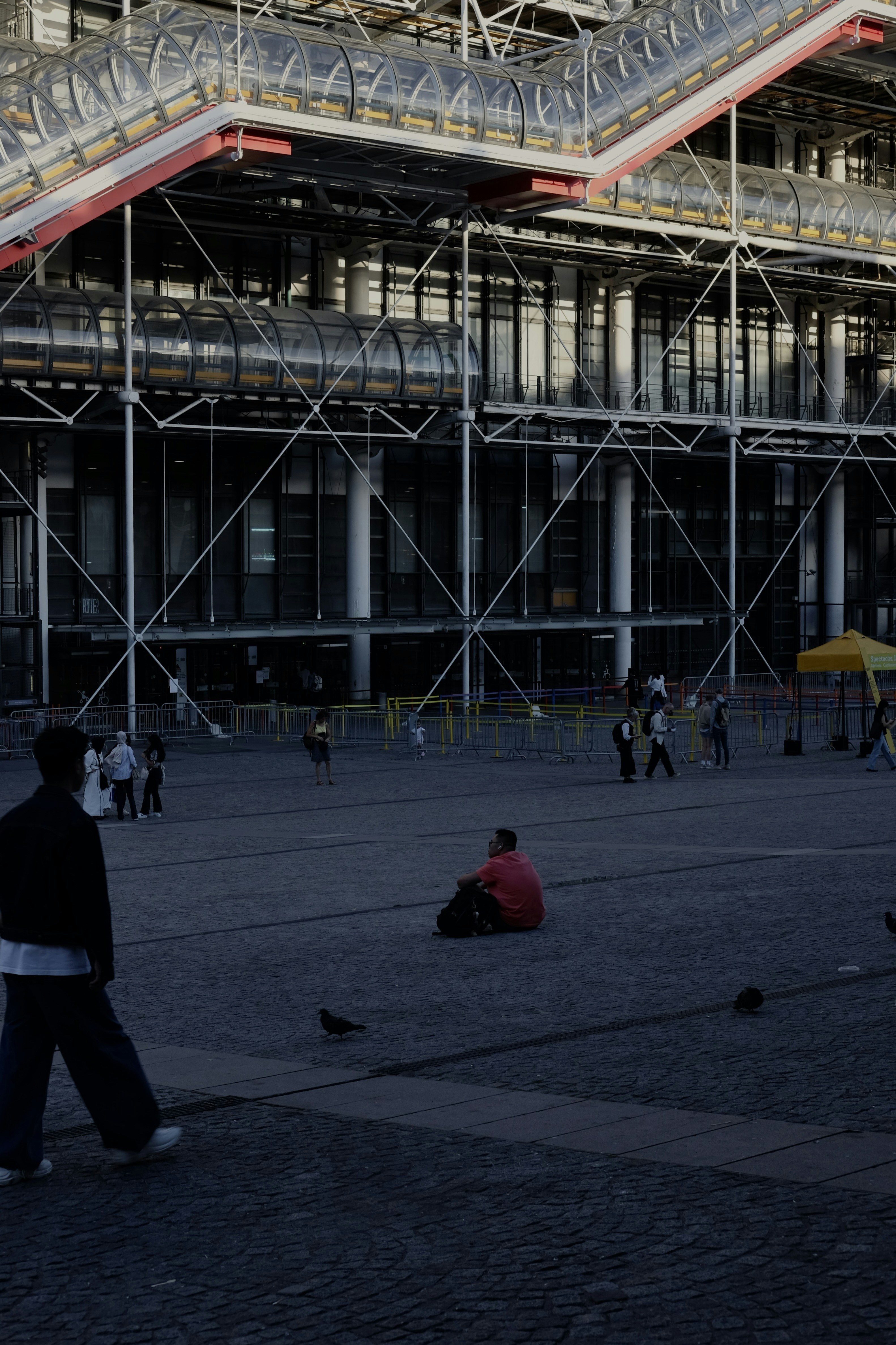 People gather in a plaza in front of modern architecture.