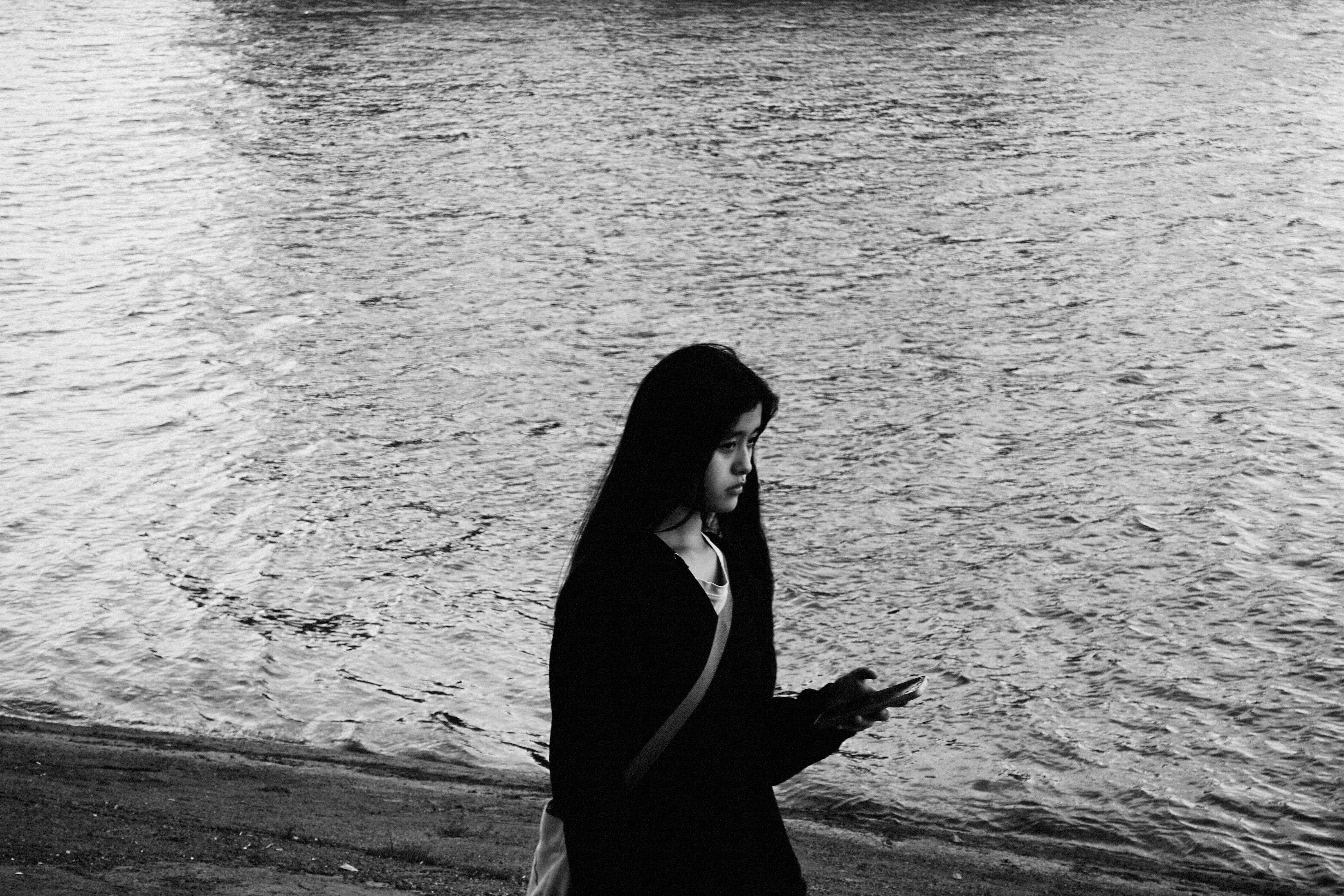 A close-up of a person looking at their smartphone with a puzzled and contemplative expression, wondering about a short text message they just received.