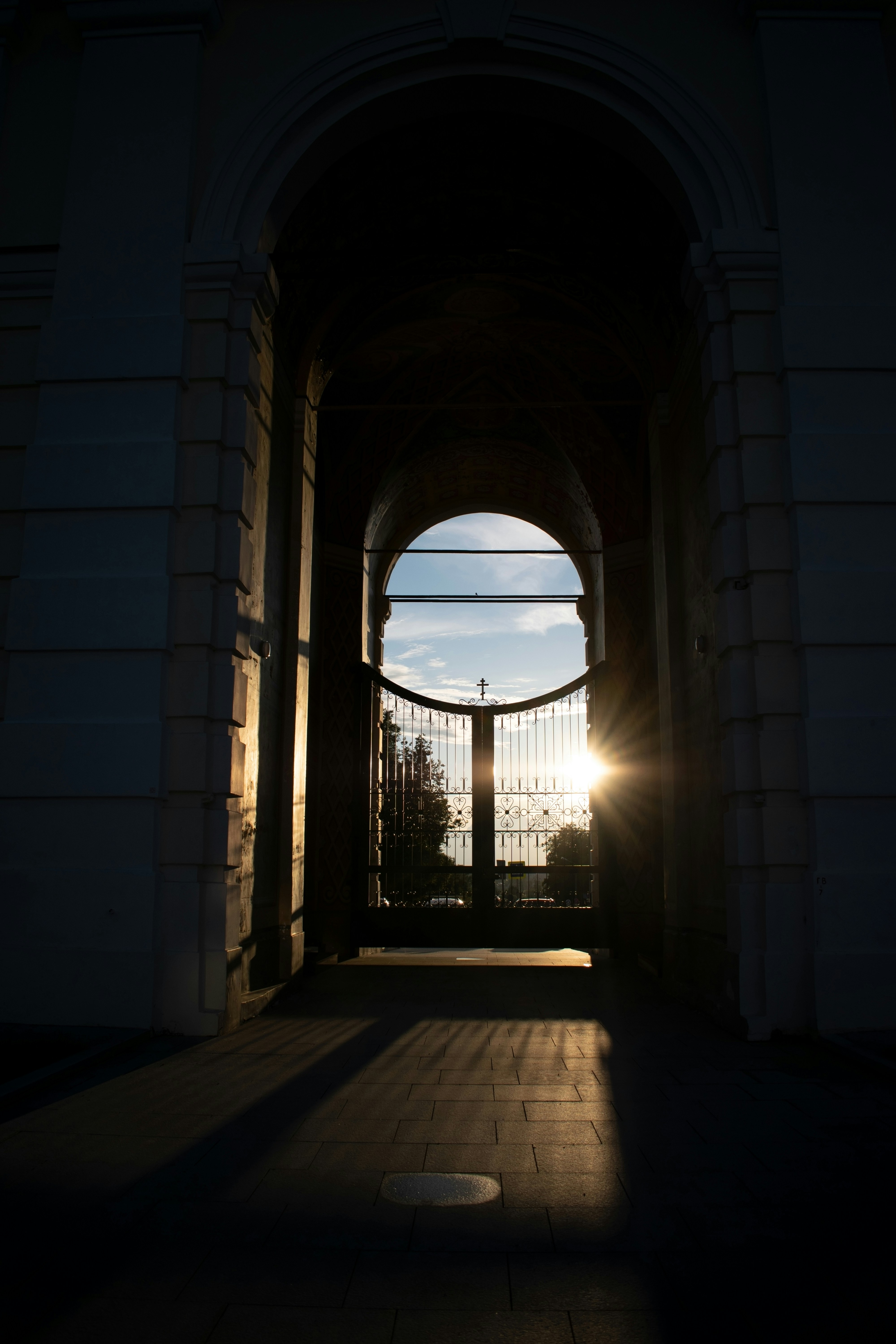 La luz del sol brilla a través de un arco y una puerta.
