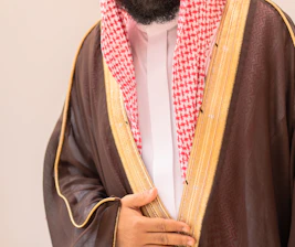 Man in traditional arabic clothing with brown thobe.