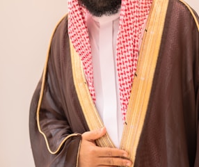 Man in traditional arabic clothing with brown thobe.