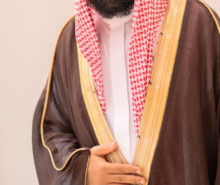 Man in traditional arabic clothing with brown thobe.
