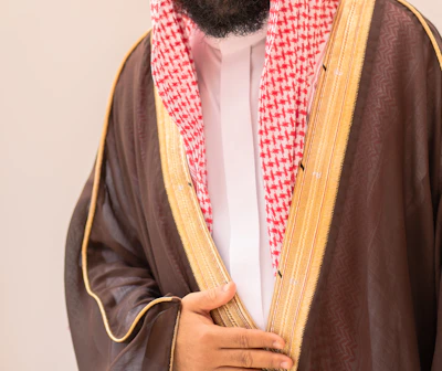 Man in traditional arabic clothing with brown thobe.
