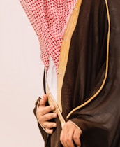 Man in traditional saudi clothing with red and white headdress.