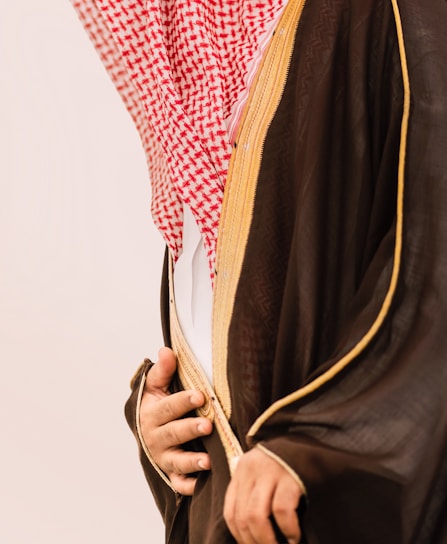 Man in traditional saudi clothing with red and white headdress.
