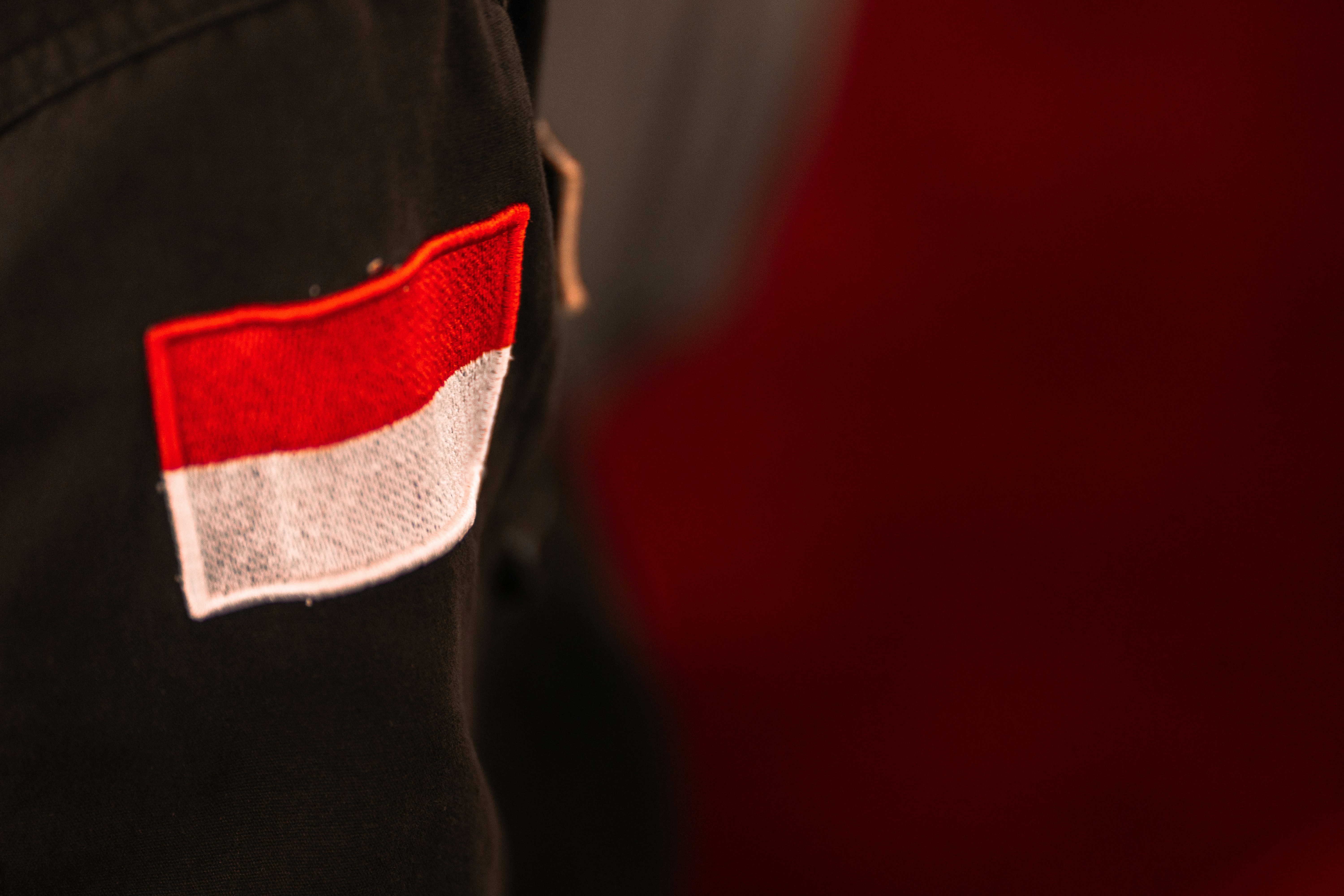 Close-up of an indonesian flag patch on black fabric.