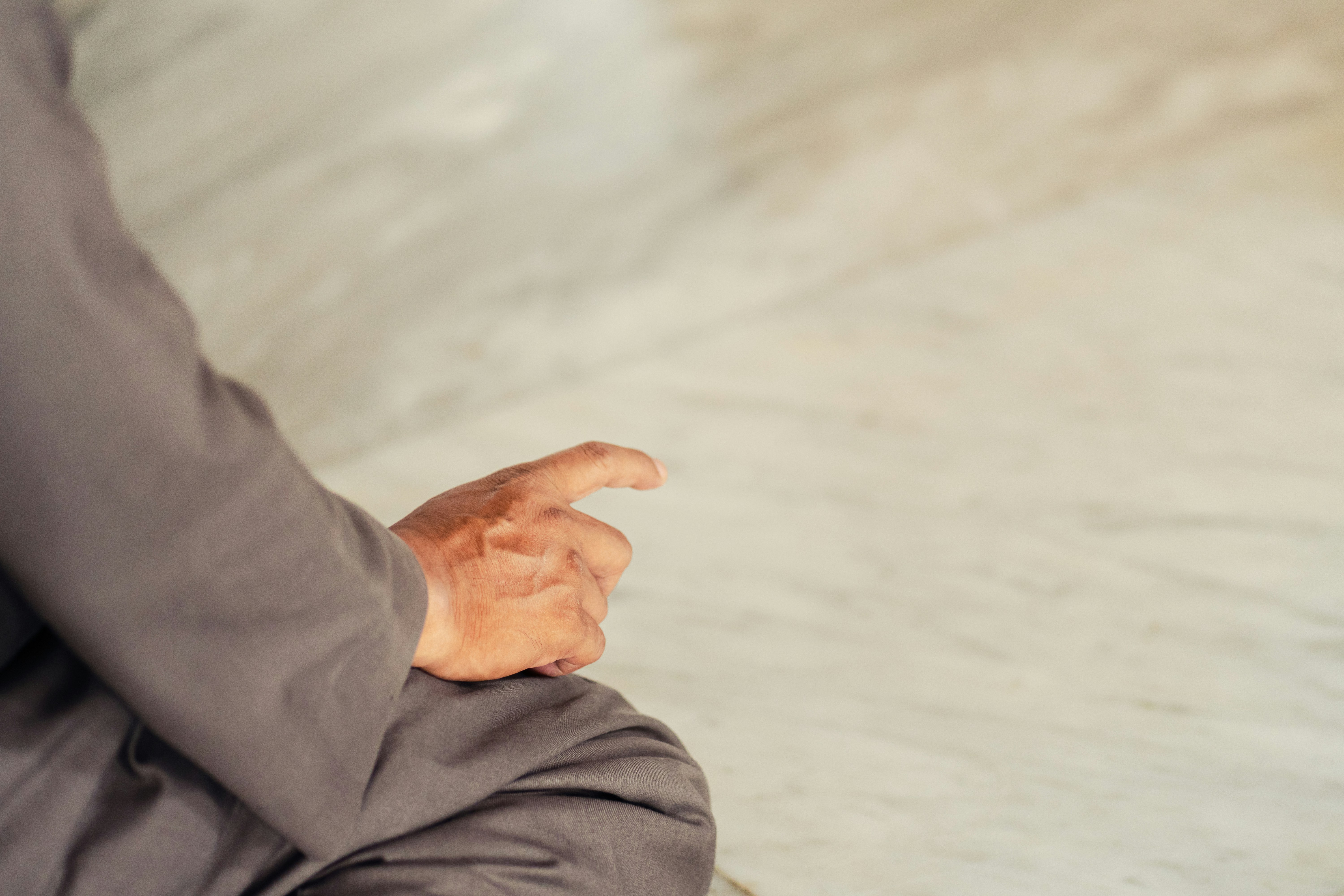 Person sitting with finger pointing forward