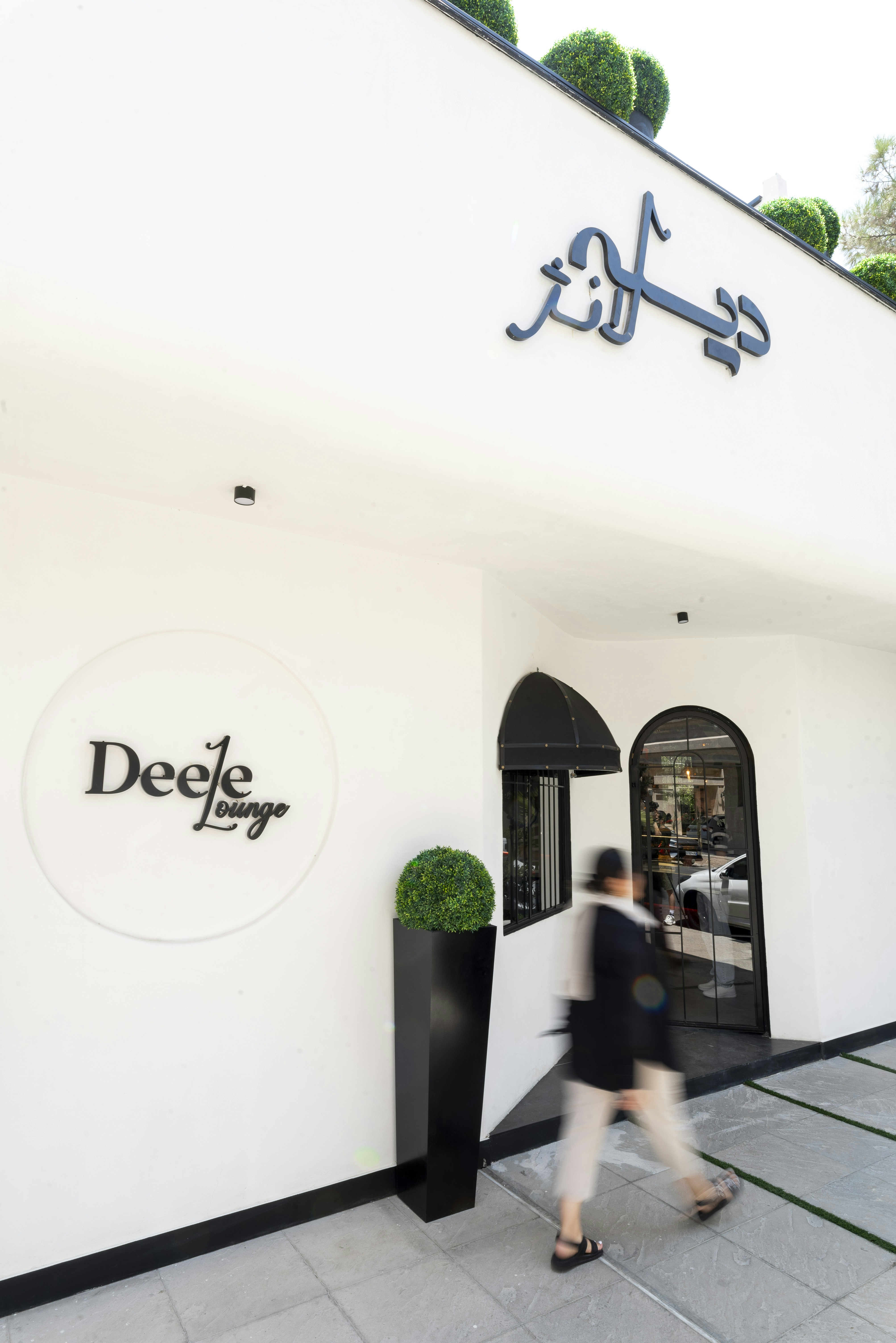 Modern building entrance with arabic and english signage.