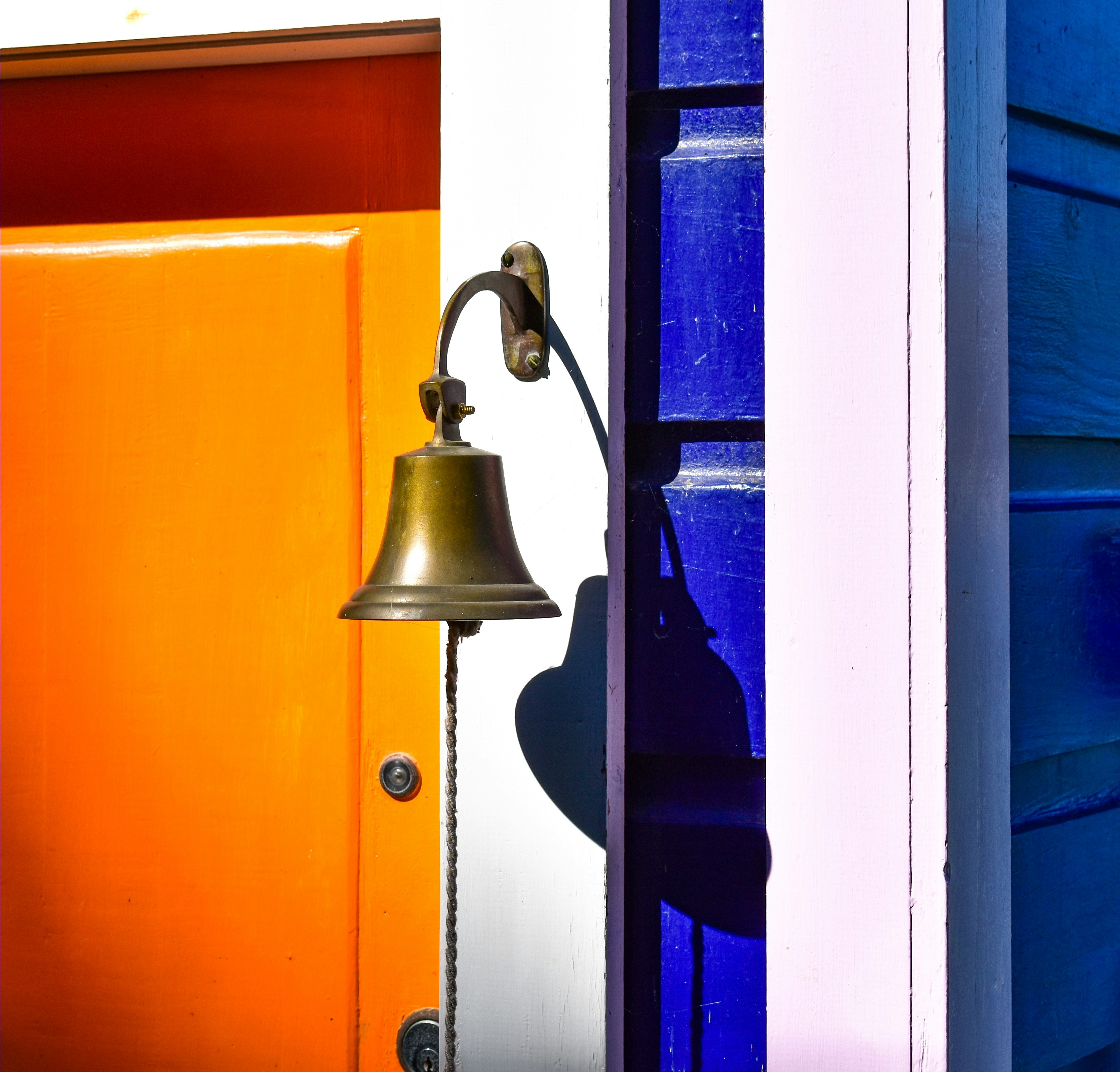 notify: Brass bell hangs on a colorful door