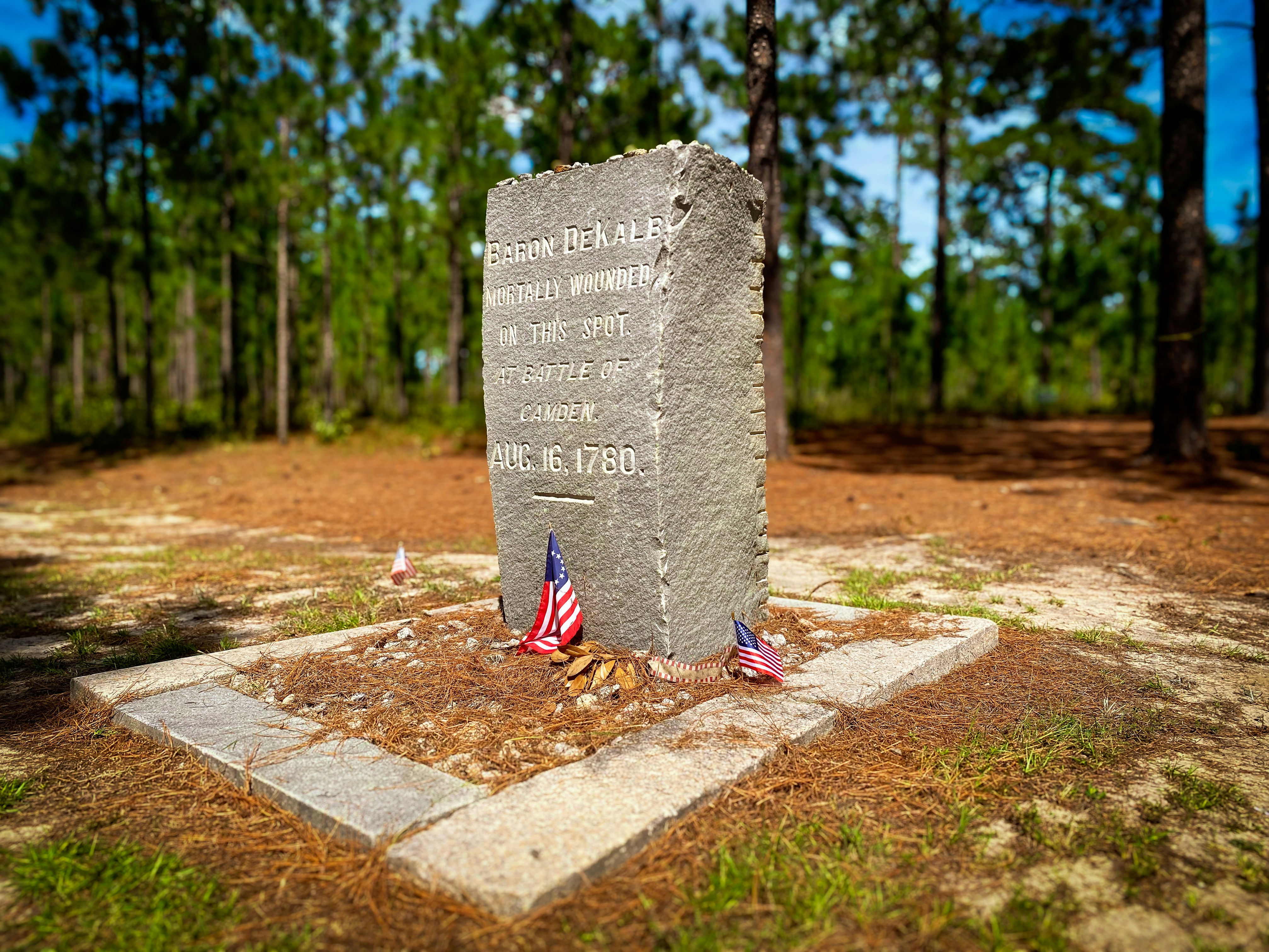 Stone monument with american flags in forest