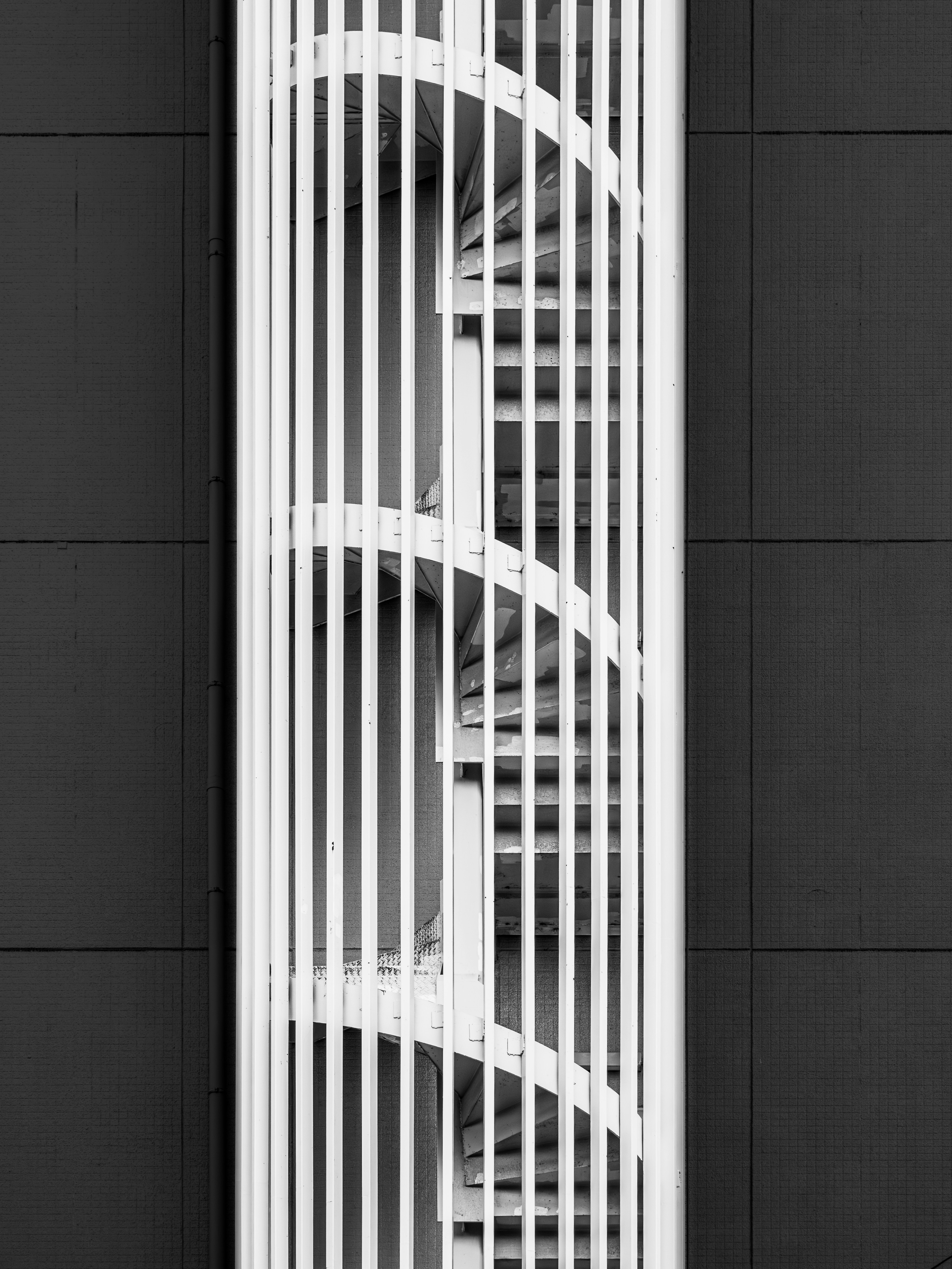 Scala a chiocciola bianca contro un edificio scuro