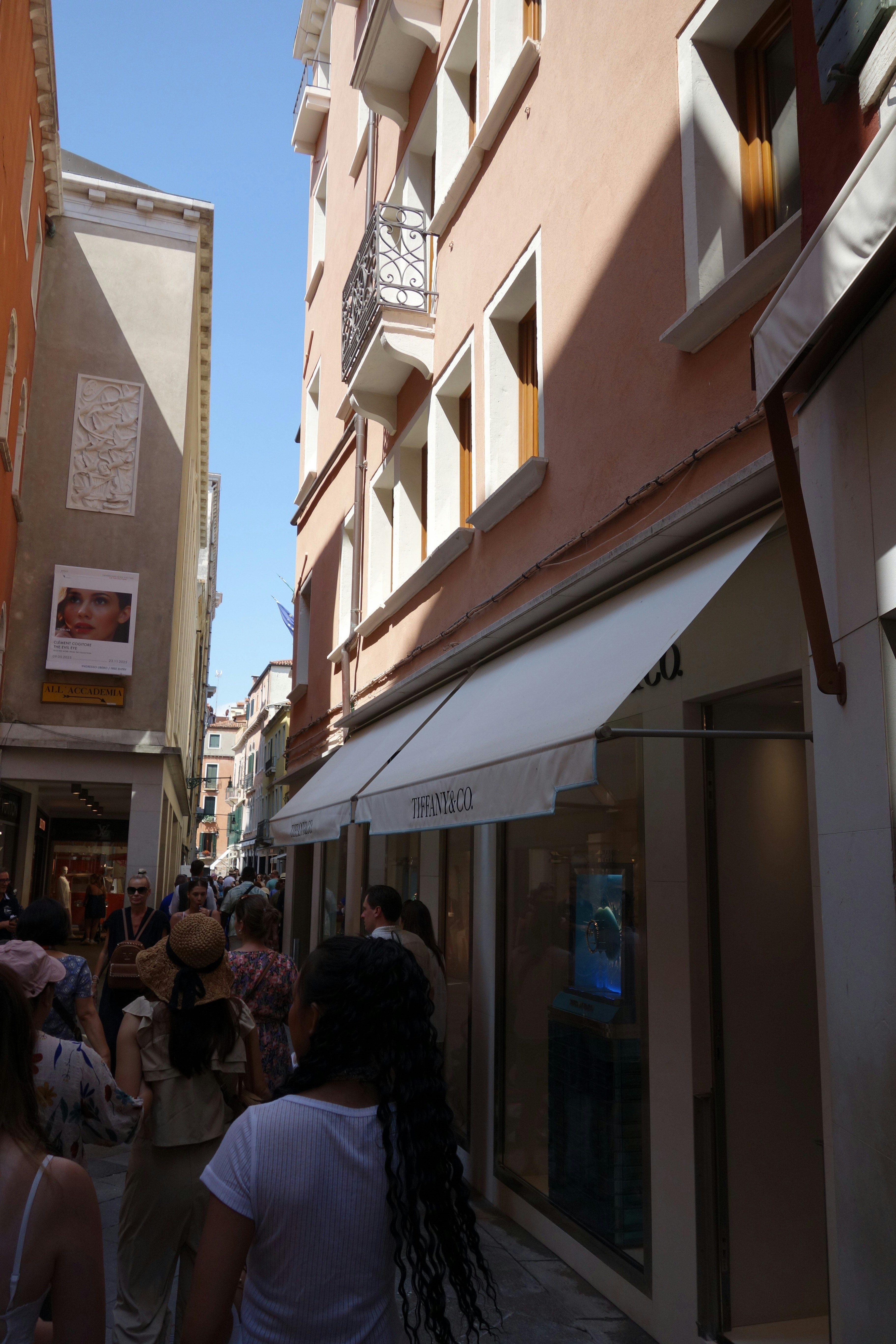 People walking down a narrow street with buildings.