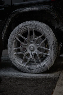 Close-up of a car wheel covered in white foam.