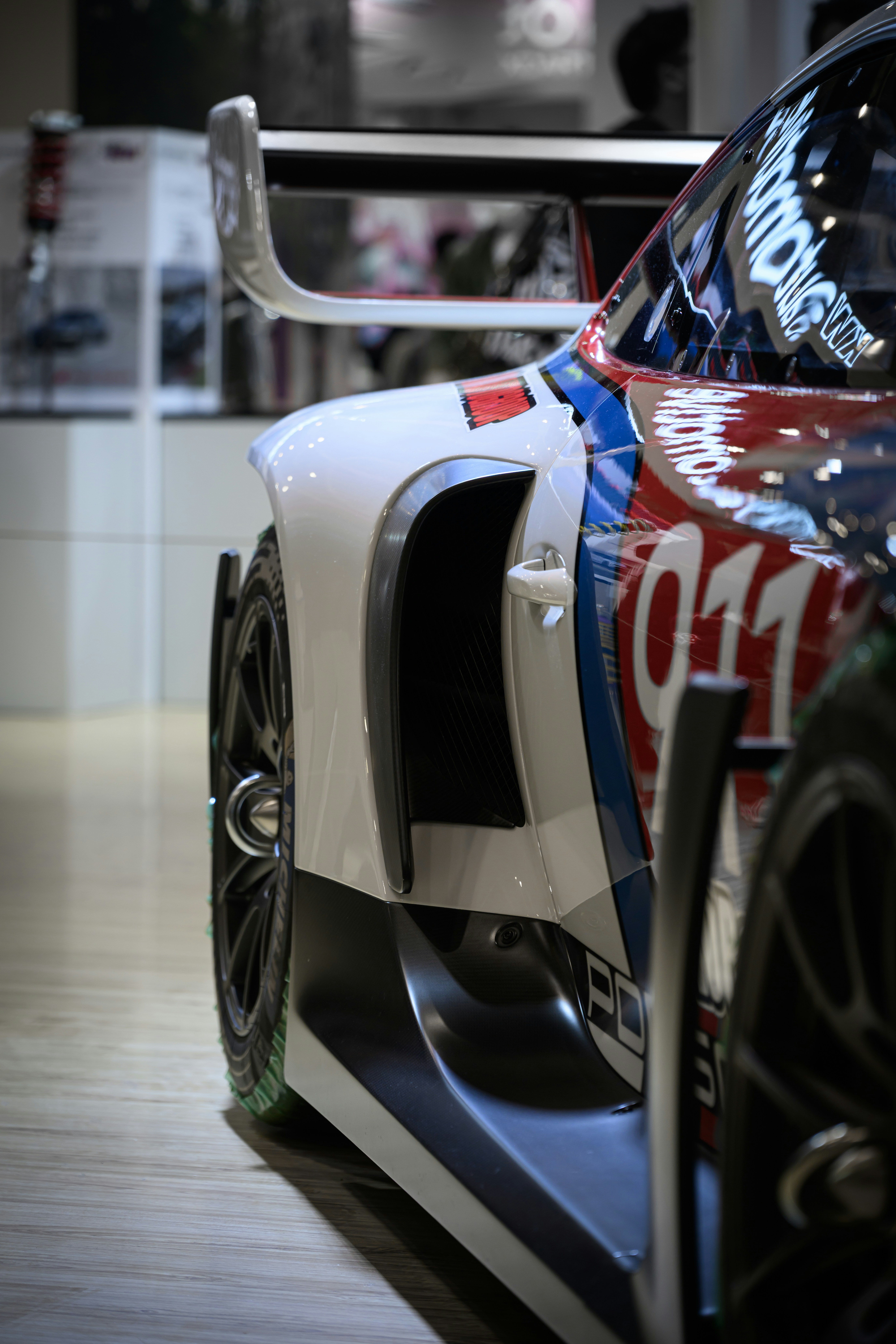 Close-up of a white racing car with red and blue accents.