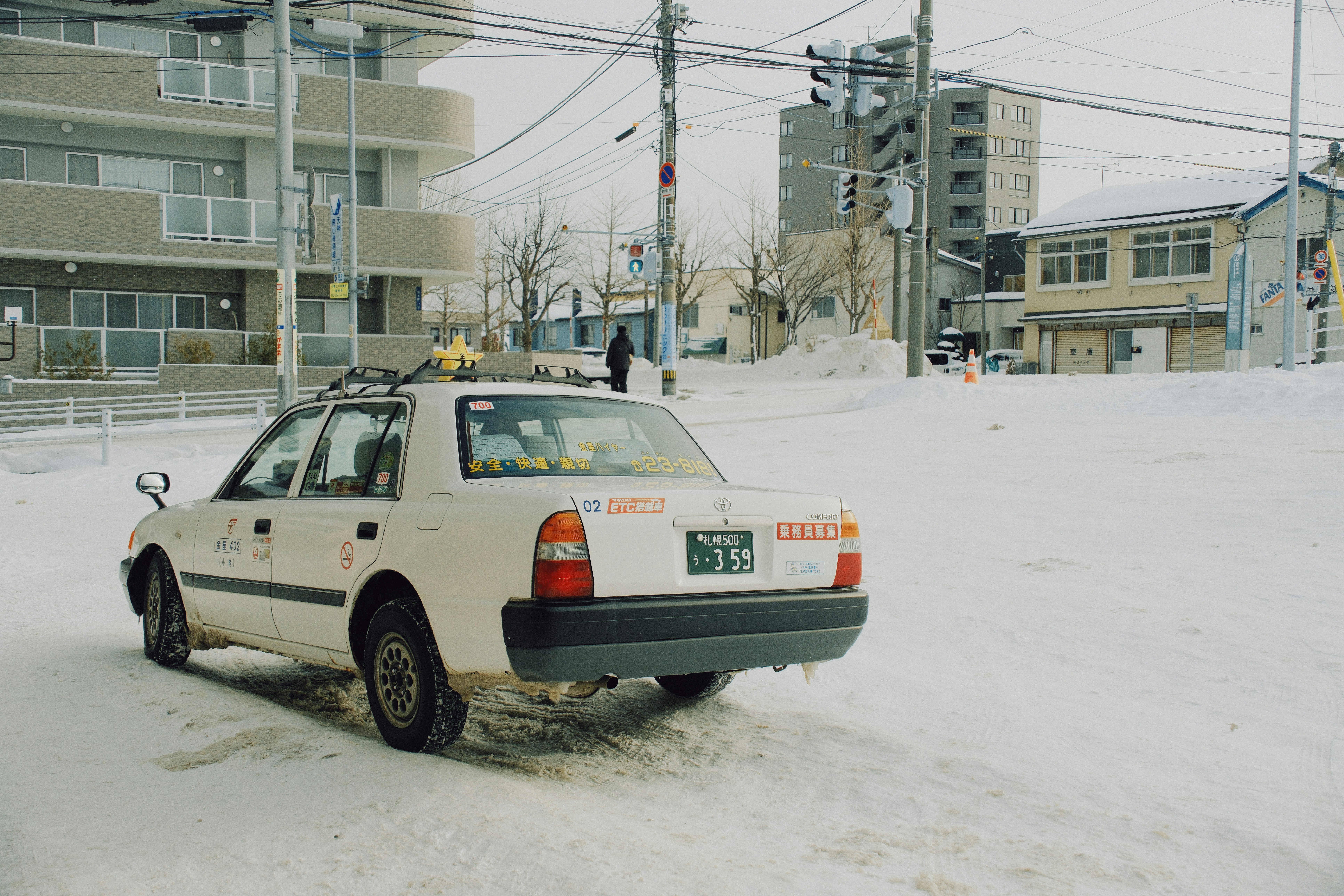 Car with snow tires driving on a snow-covered road in Japan