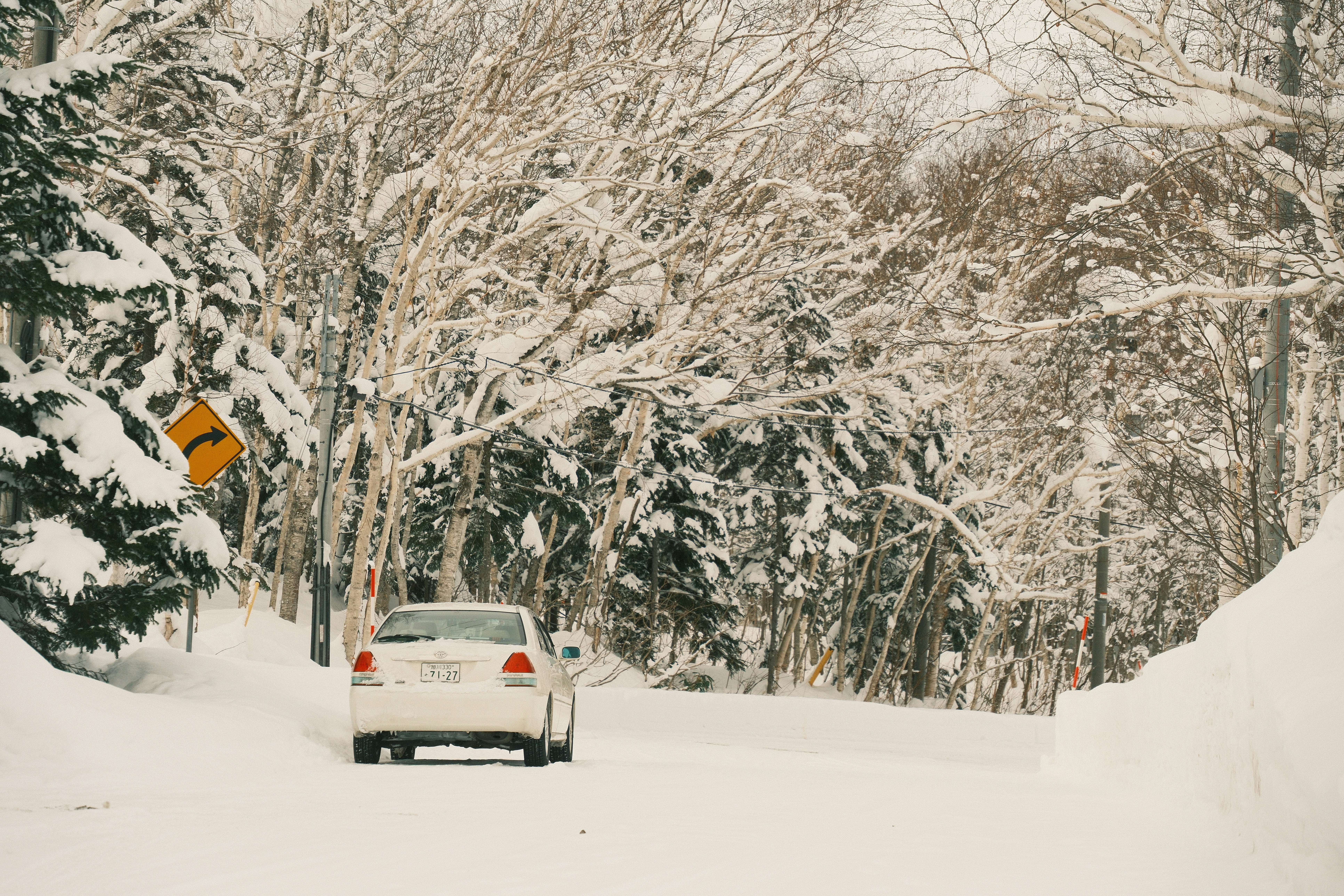 Car driving carefully on a snowy road in Hokkaido
