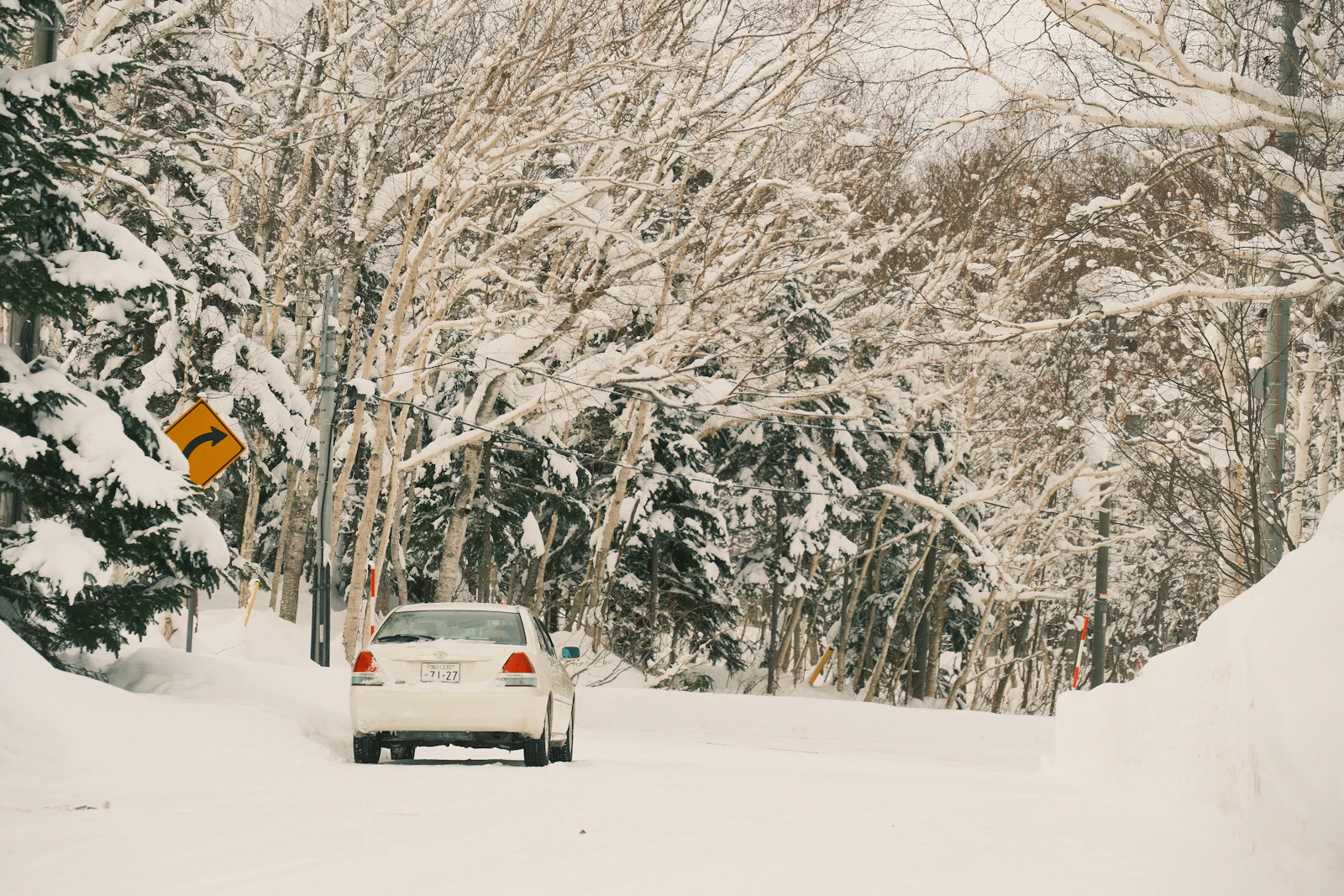 A road crosses a snowy mountain landscape in Japan
