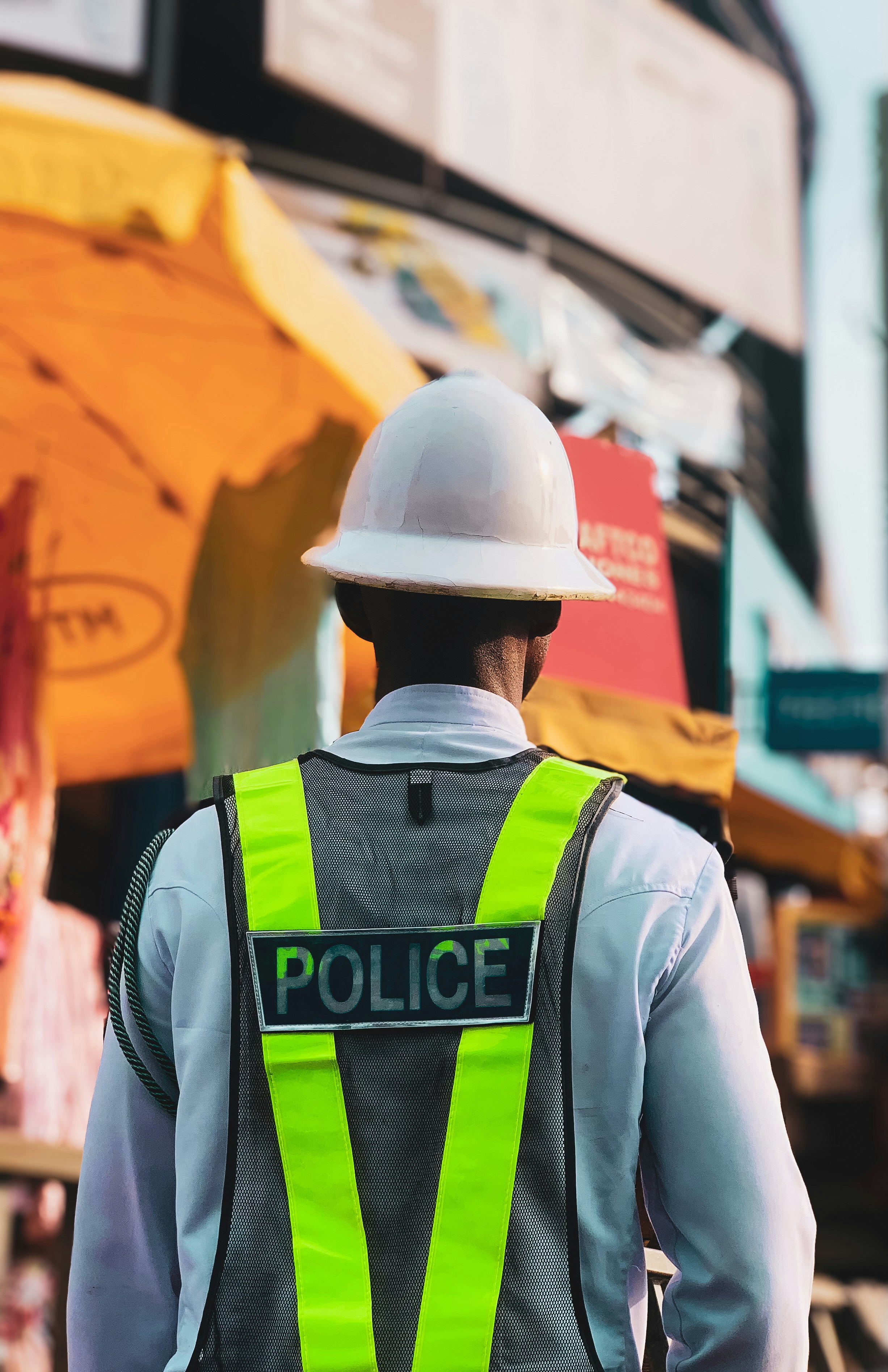 Policeman wearing a reflective vest and hard hat.