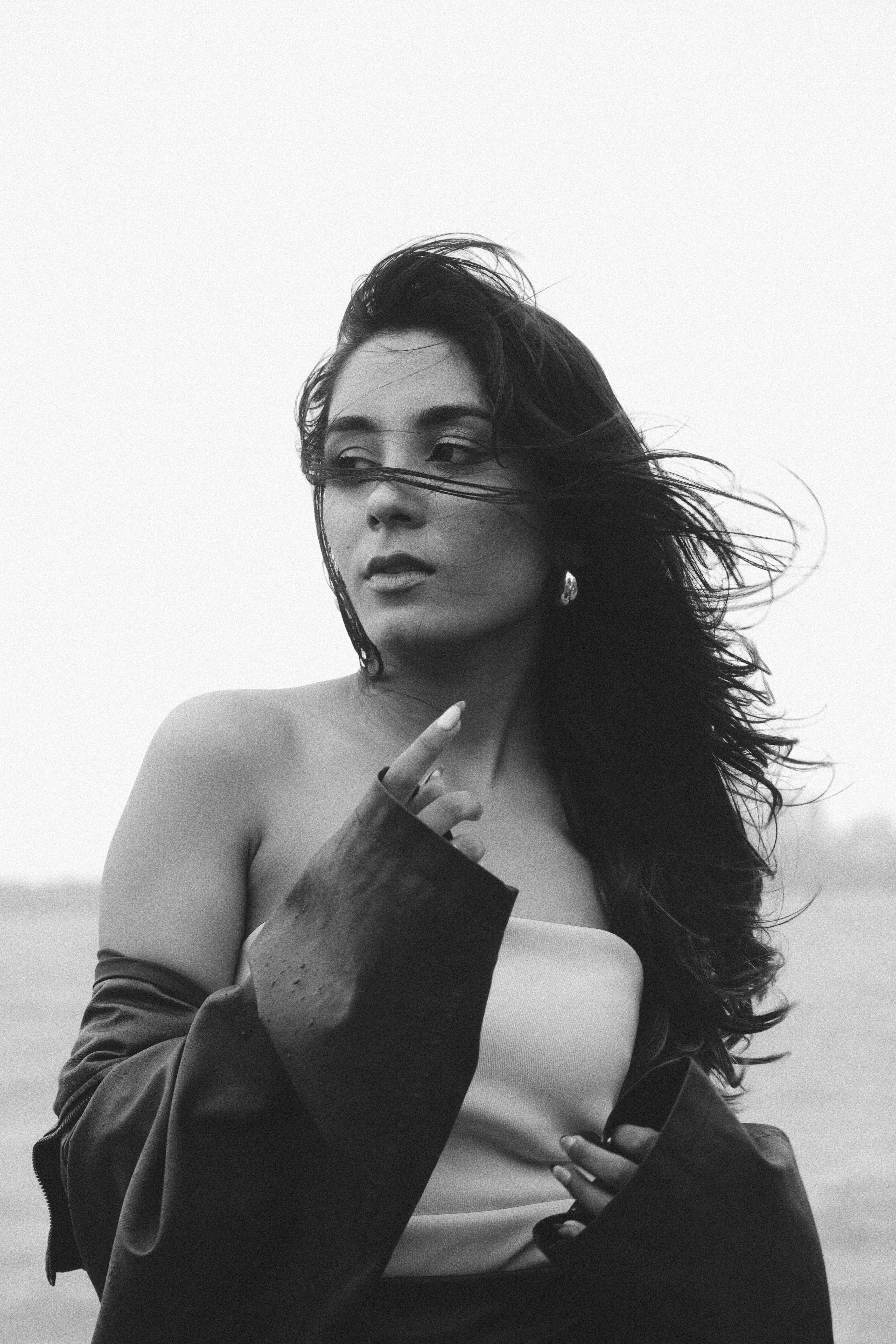 Frau mit windzerzaustem Haar, die wegschaut