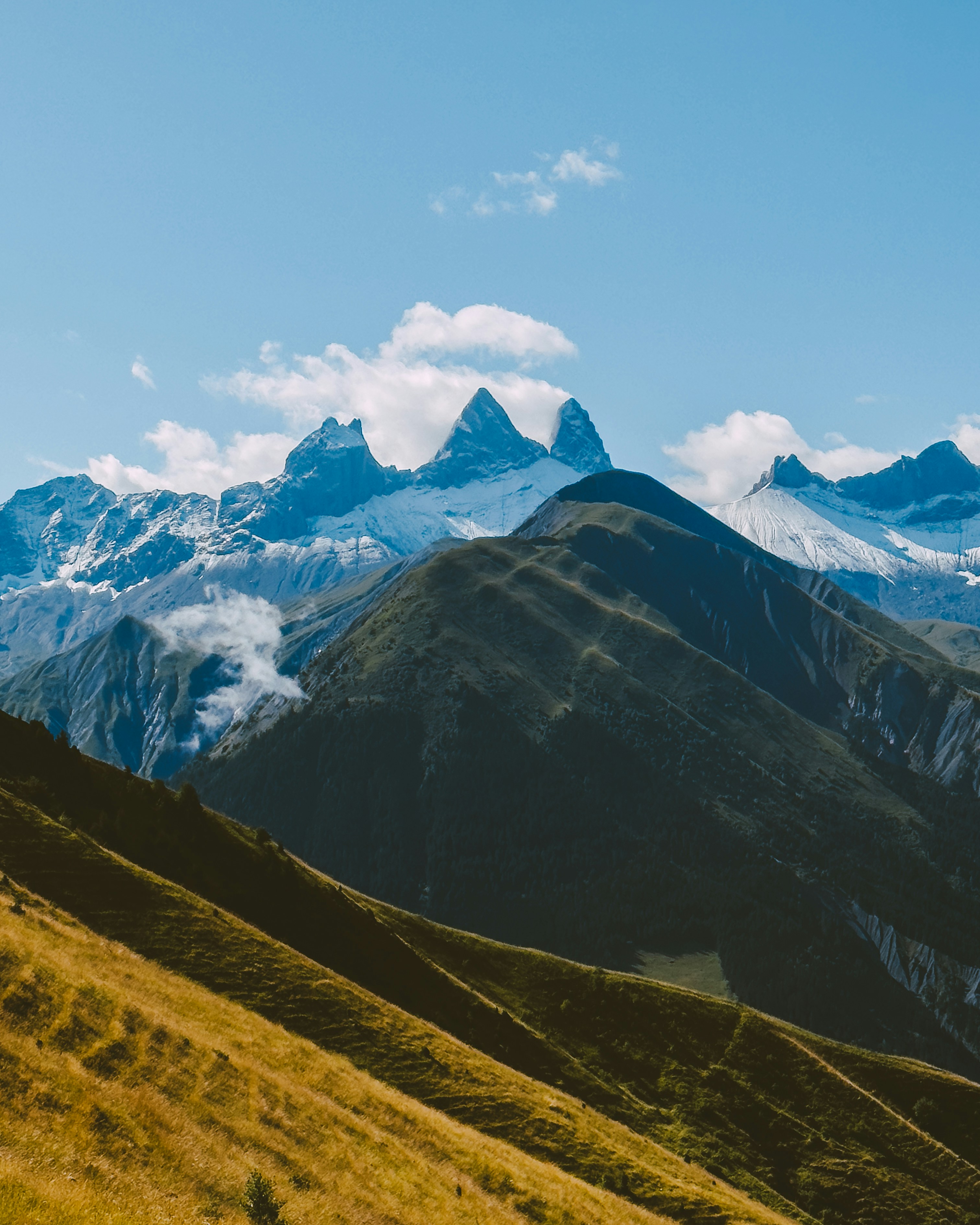 Montañas nevadas escarpadas bajo un cielo azul.