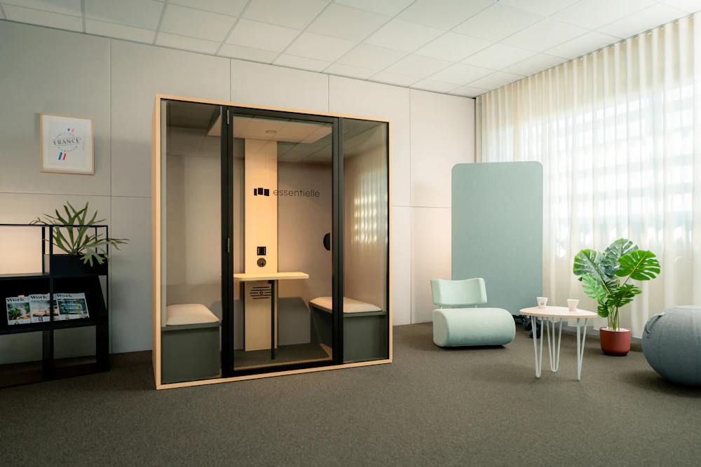 Acoustically sealed soundproof booth with a built-in desk inside the open office