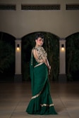 Woman in elegant green saree with ornate blouse