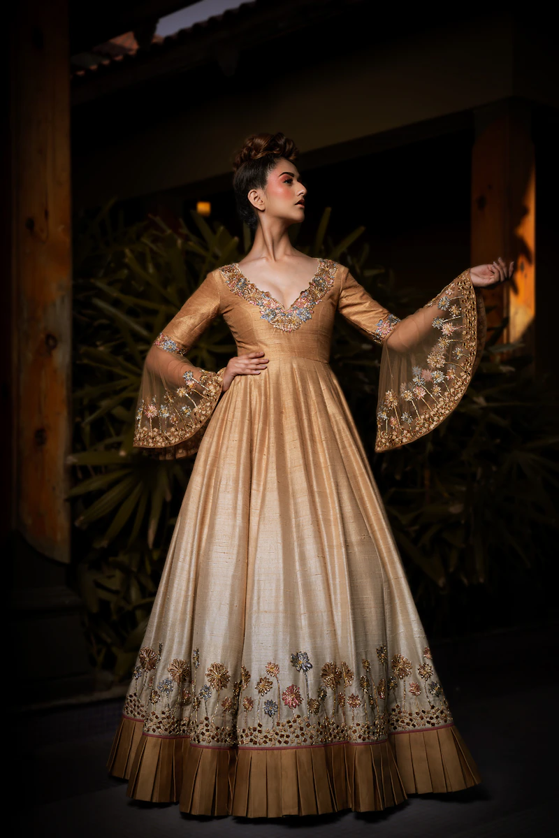 Woman in a golden gown with embroidered sleeves
