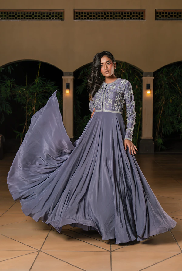 Woman in a flowing grey dress with embellishments