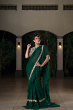 Woman in elegant green ruffled sari with gold trim.