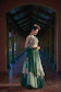 Woman in a green embroidered lehenga outfit poses elegantly.