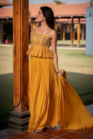 Woman in yellow peplum top and pleated skirt