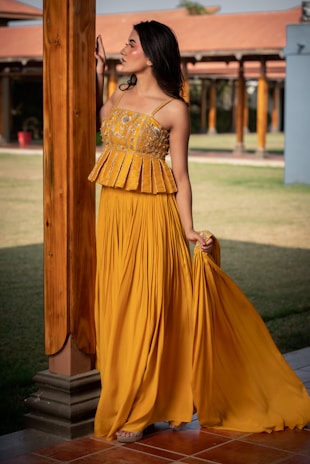 Woman in yellow peplum top and pleated skirt