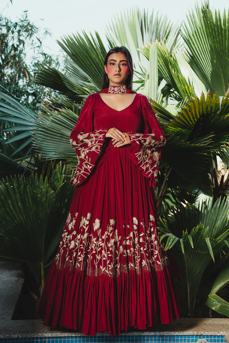 Woman in a red dress with ornate embroidered sleeves and hem
