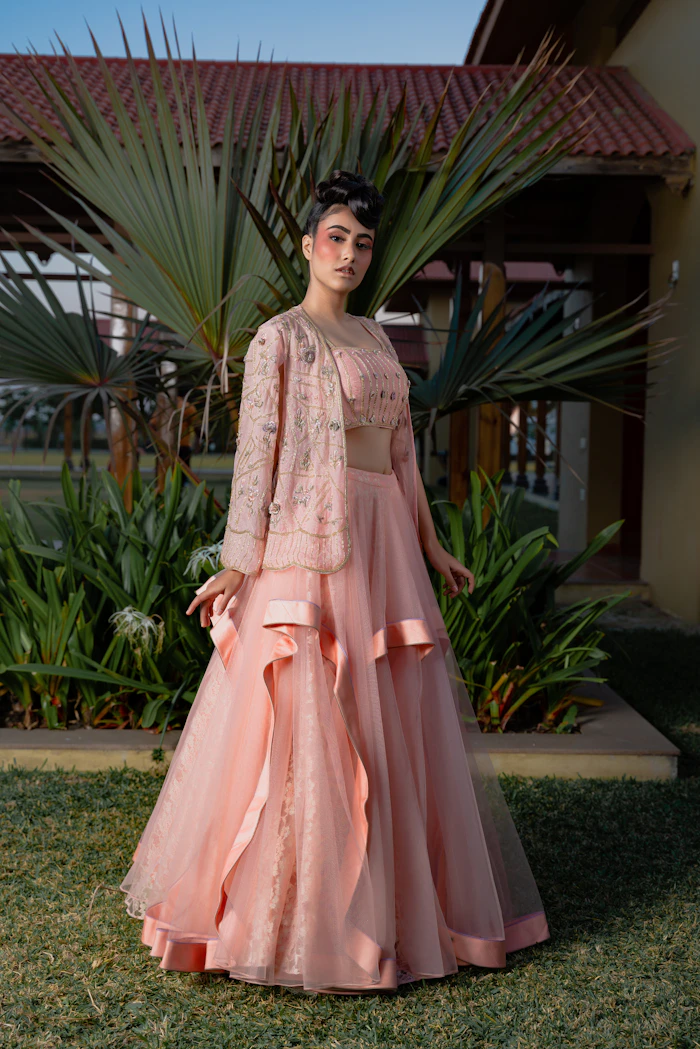 Woman wearing an elegant peach lehenga with embroidered floral jacket