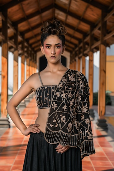 Woman in ornate black outfit with dramatic makeup