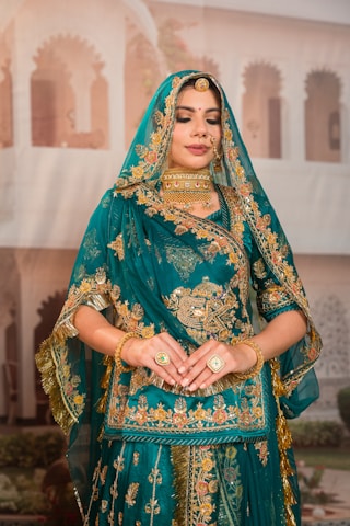 Woman in ornate teal and gold indian attire
