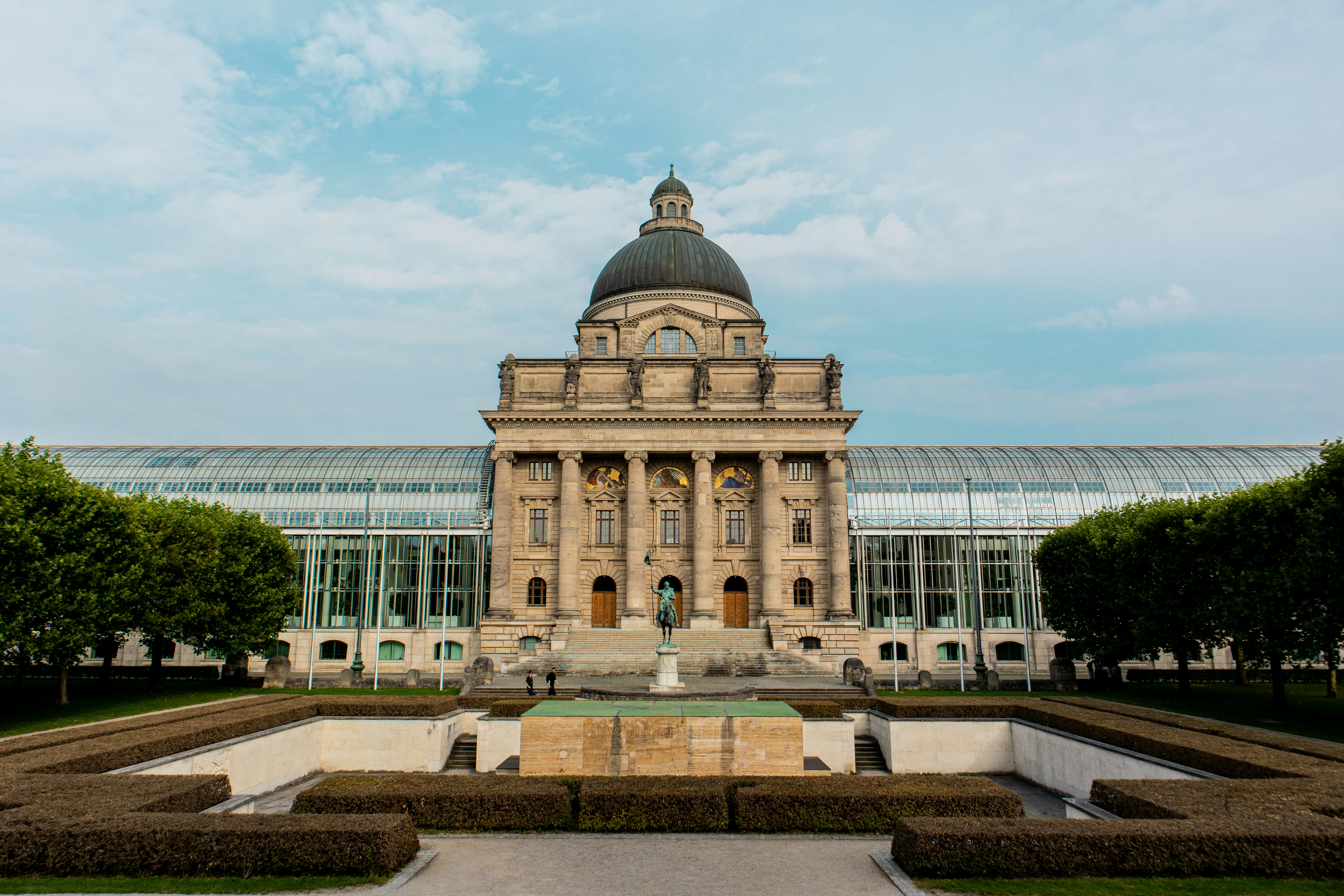 Grand building with columns and a dome, gardens