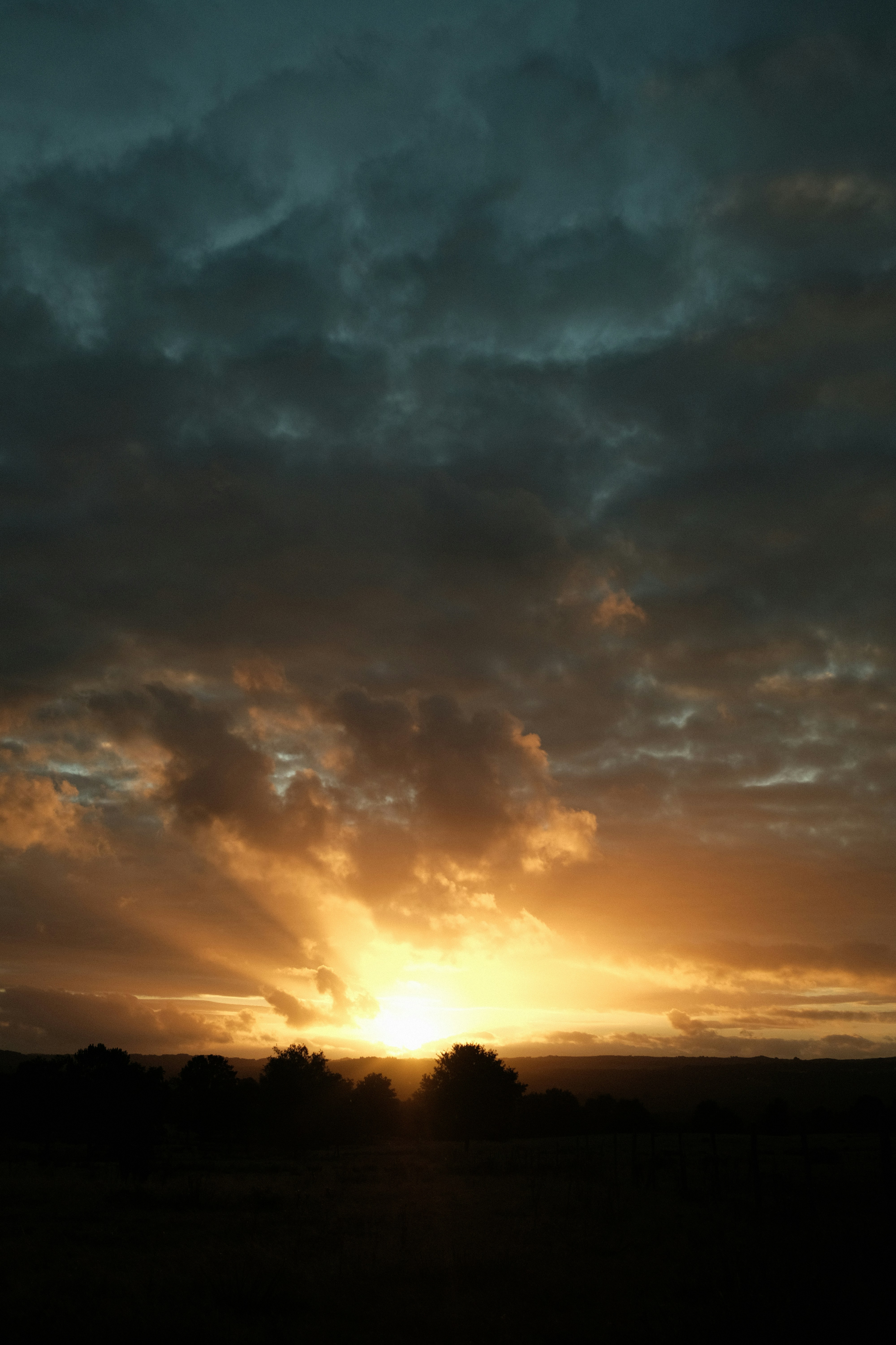 Dramatic sunset with sun rays through clouds.