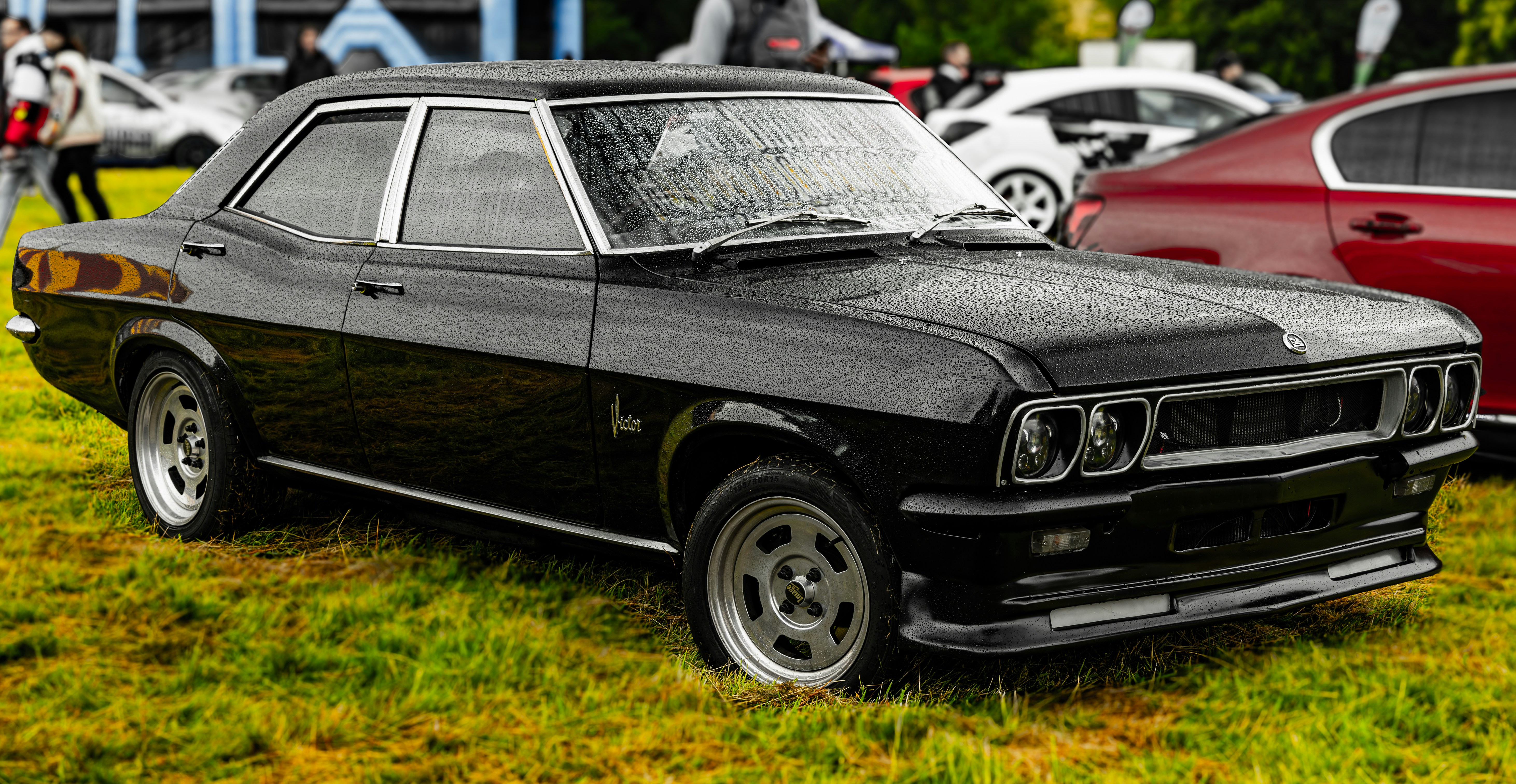 Classic black sedan parked on grassy field