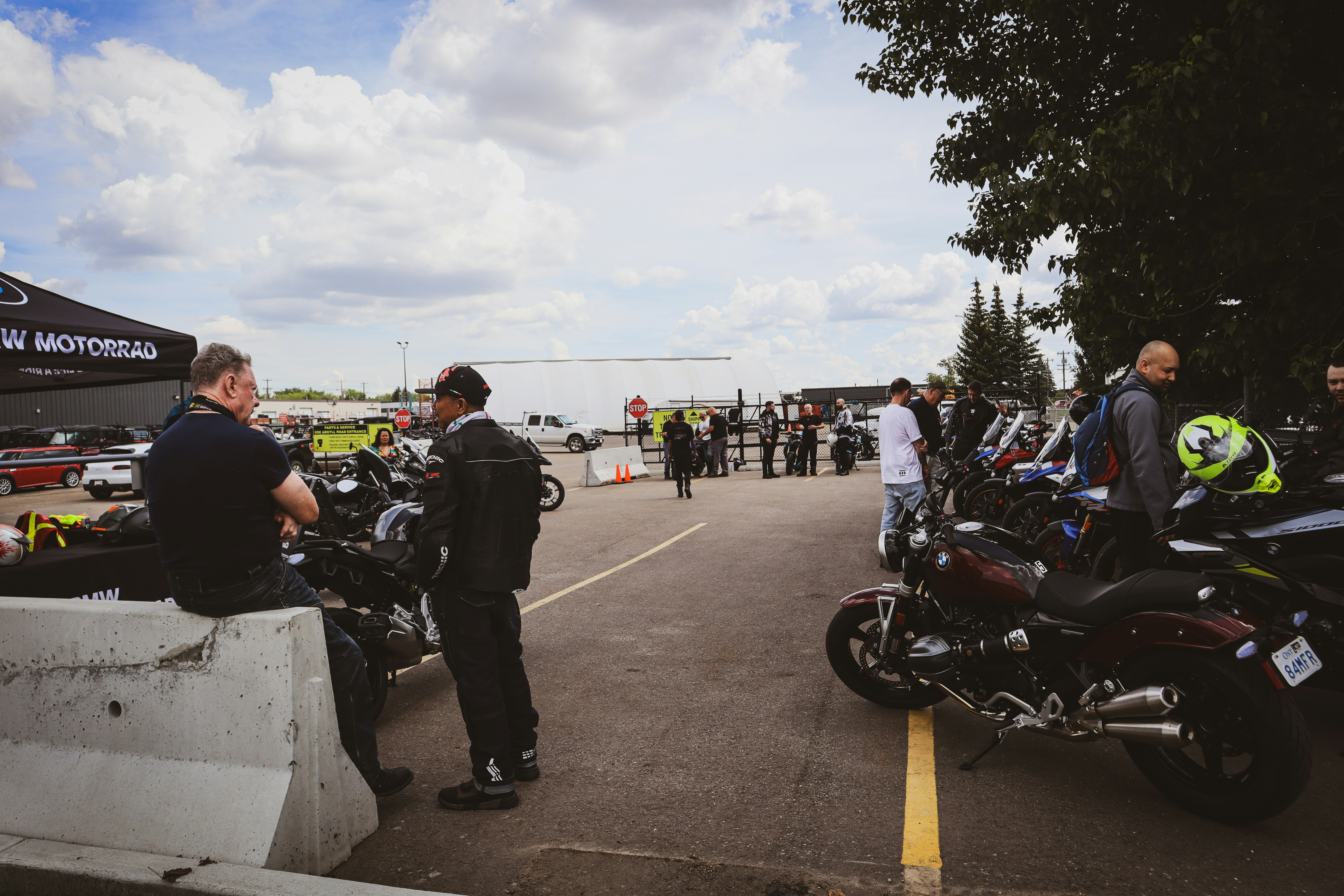 Motorcyklister i køredragt snakker sammen på en parkeringsplads.