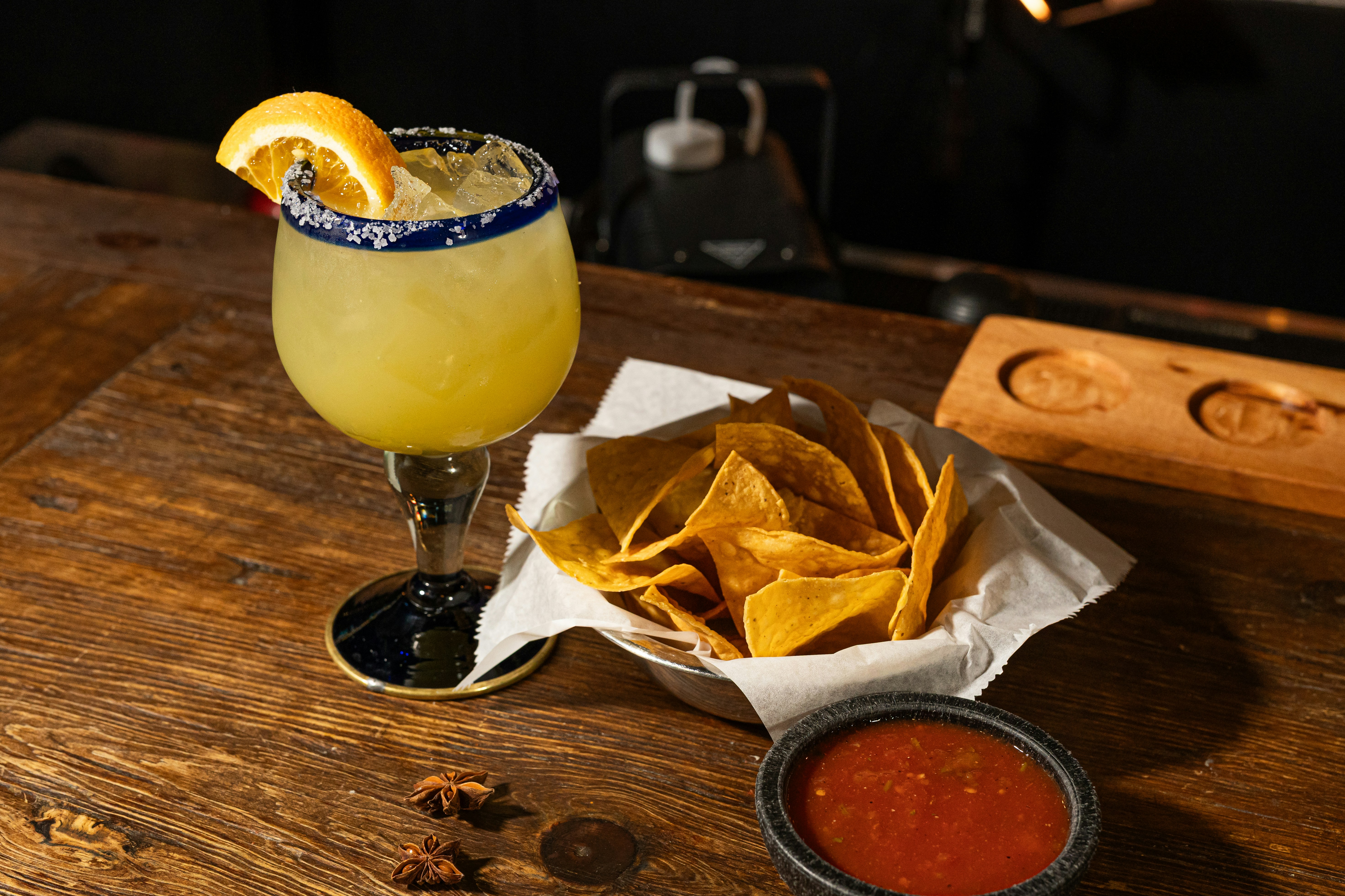 Margarita with salt rim and orange slice, served with chips and salsa.
