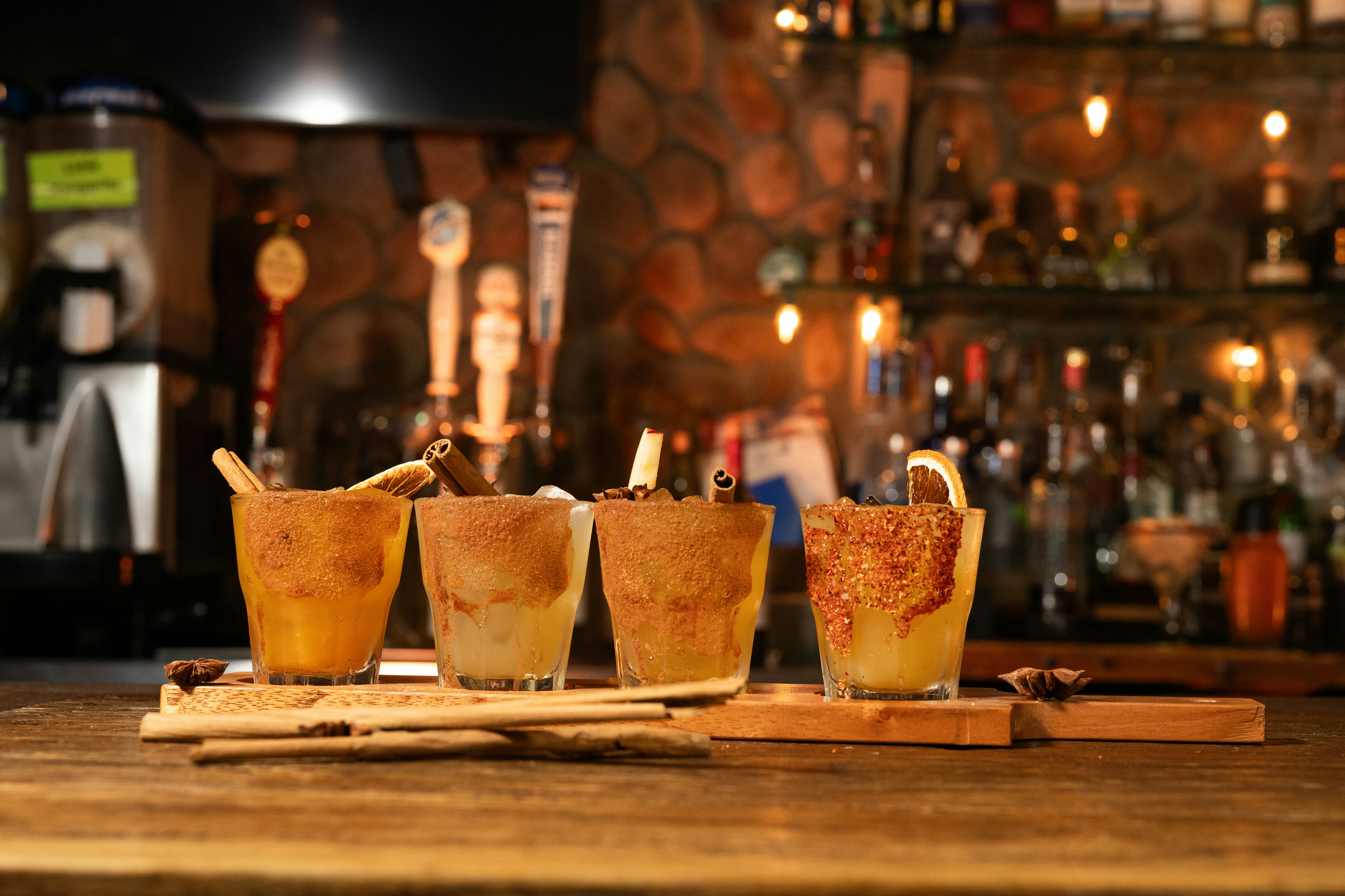 Four dessert shots lined up on a bar counter.