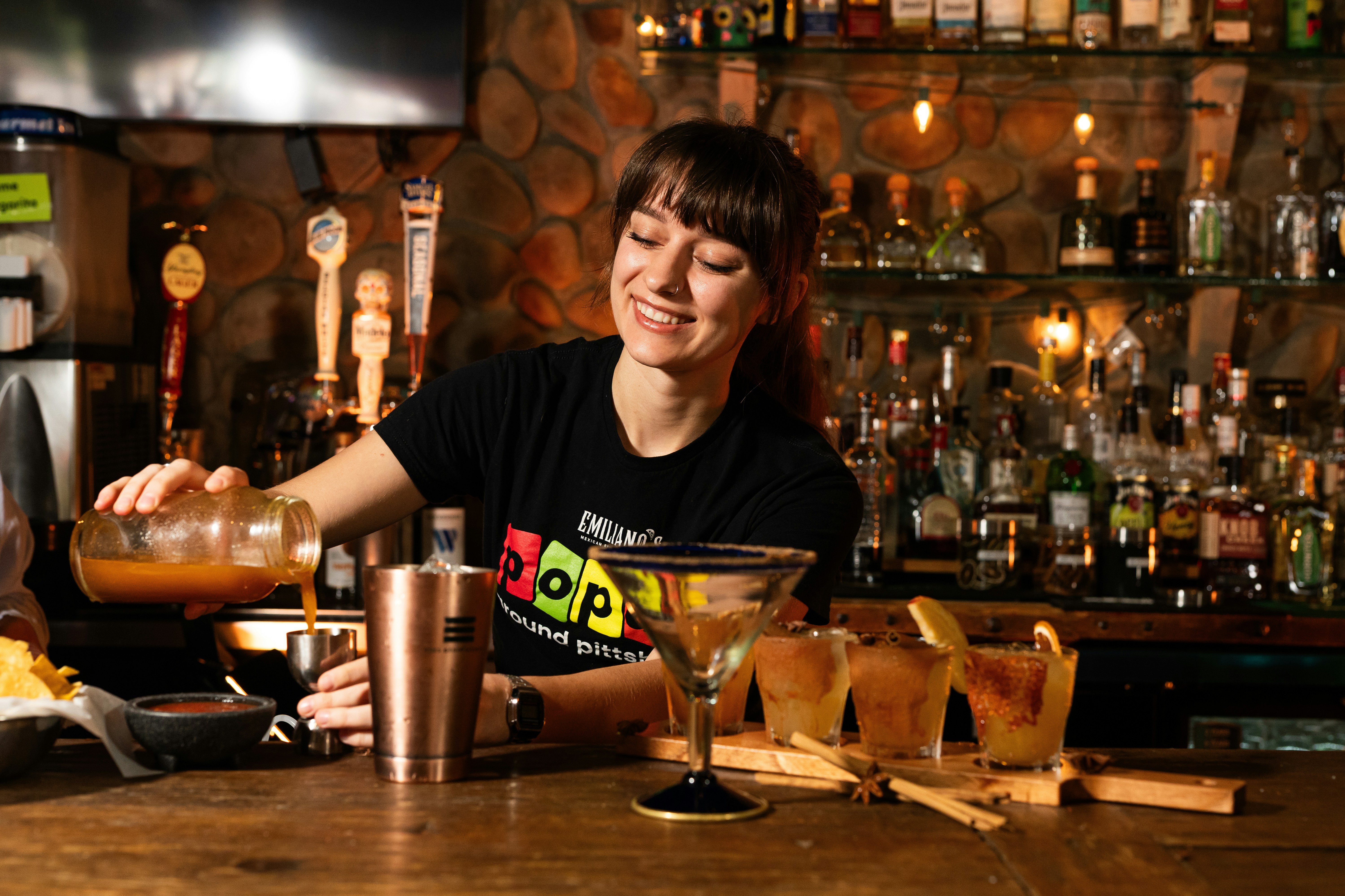 Bartender pouring drink behind a bar counter