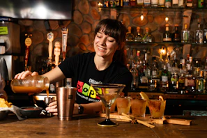 Bartender pouring drink behind a bar counter