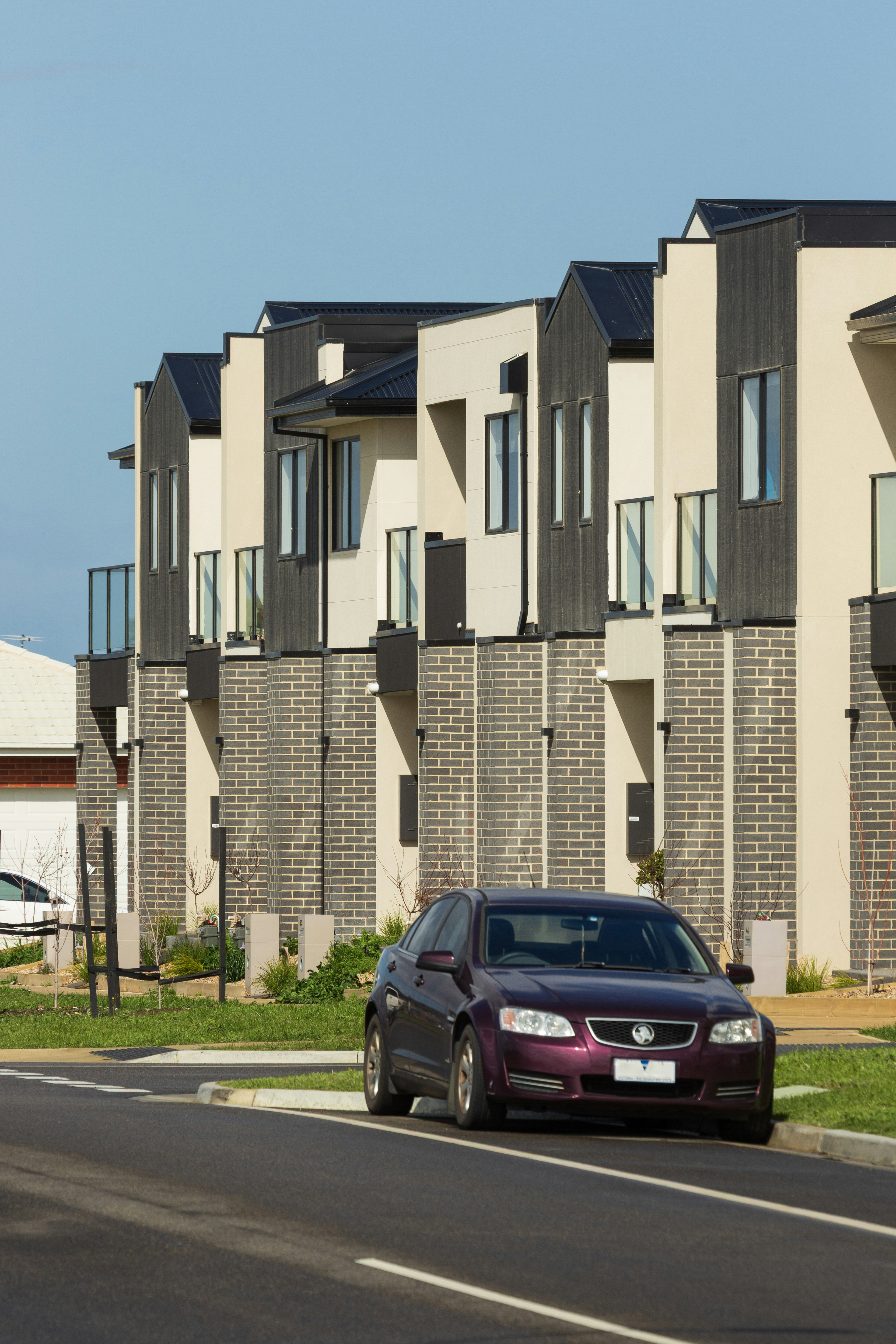 Modern townhouses with a purple car parked outside.