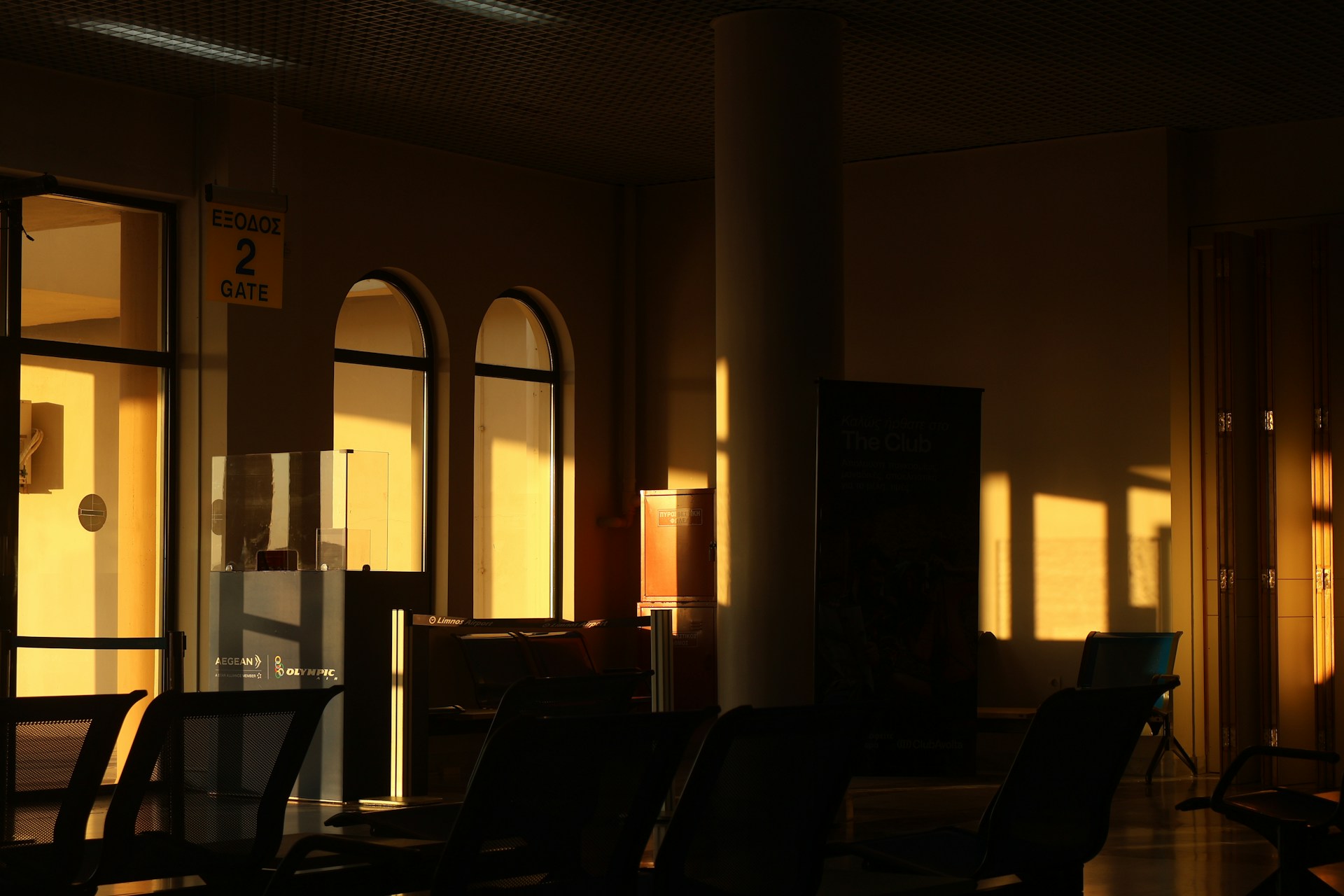 Sunlight streams through arched windows in a waiting area.