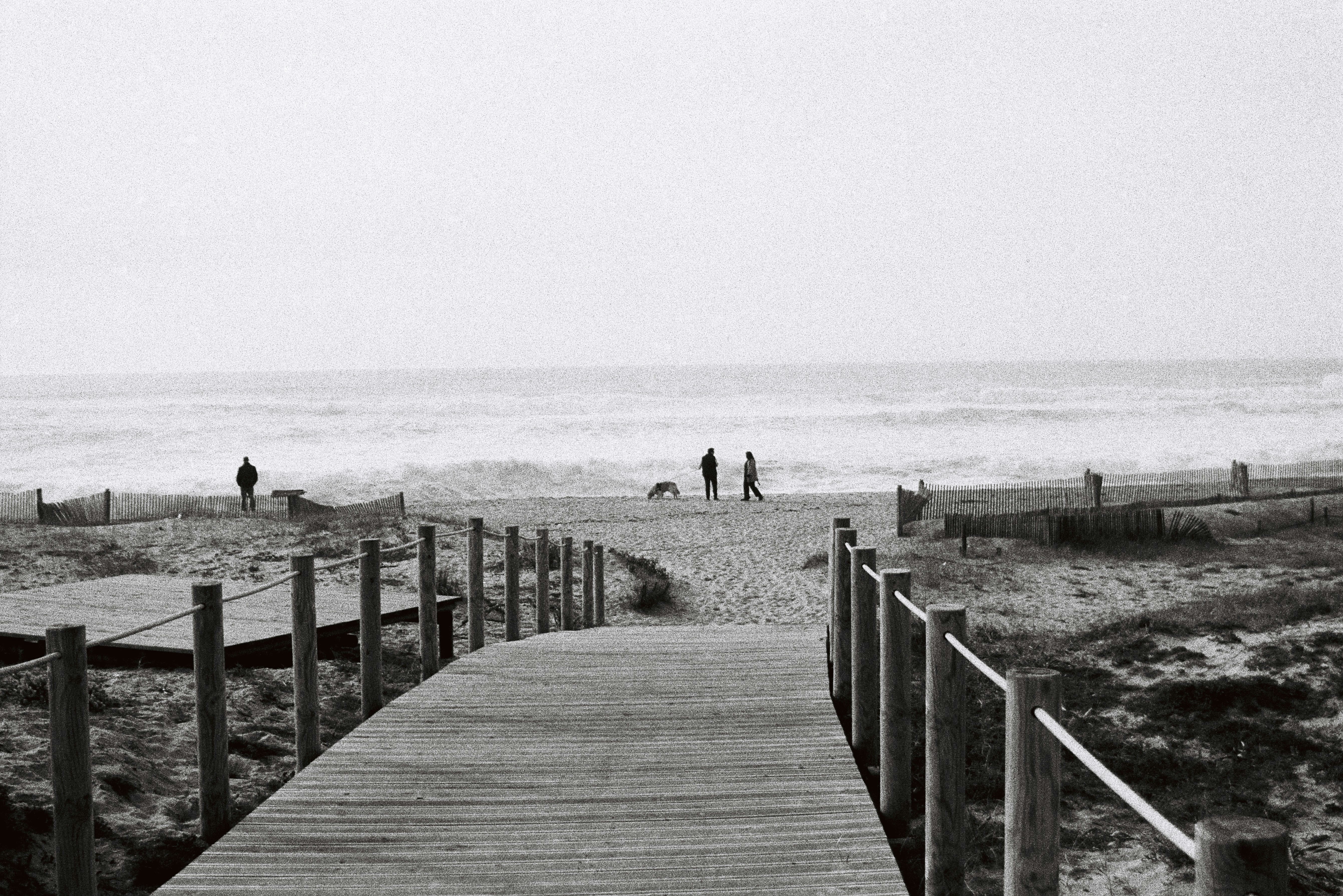 Wooden walkway leads to a sandy beach and ocean.